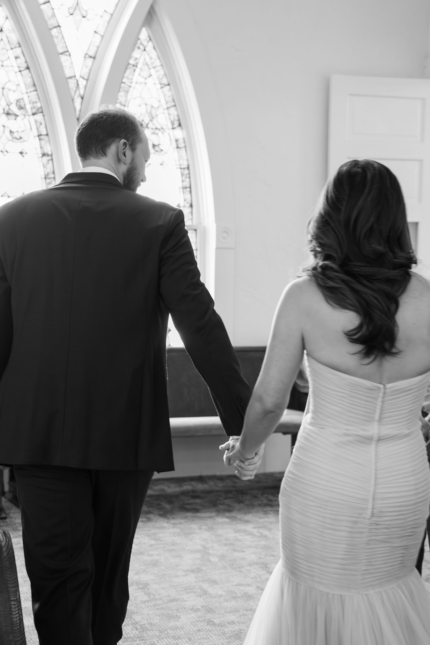 ©AnnaVonRiesenPhotography Wedding Photography | B&W image of the bride & groom walking down the aisle holding hands.