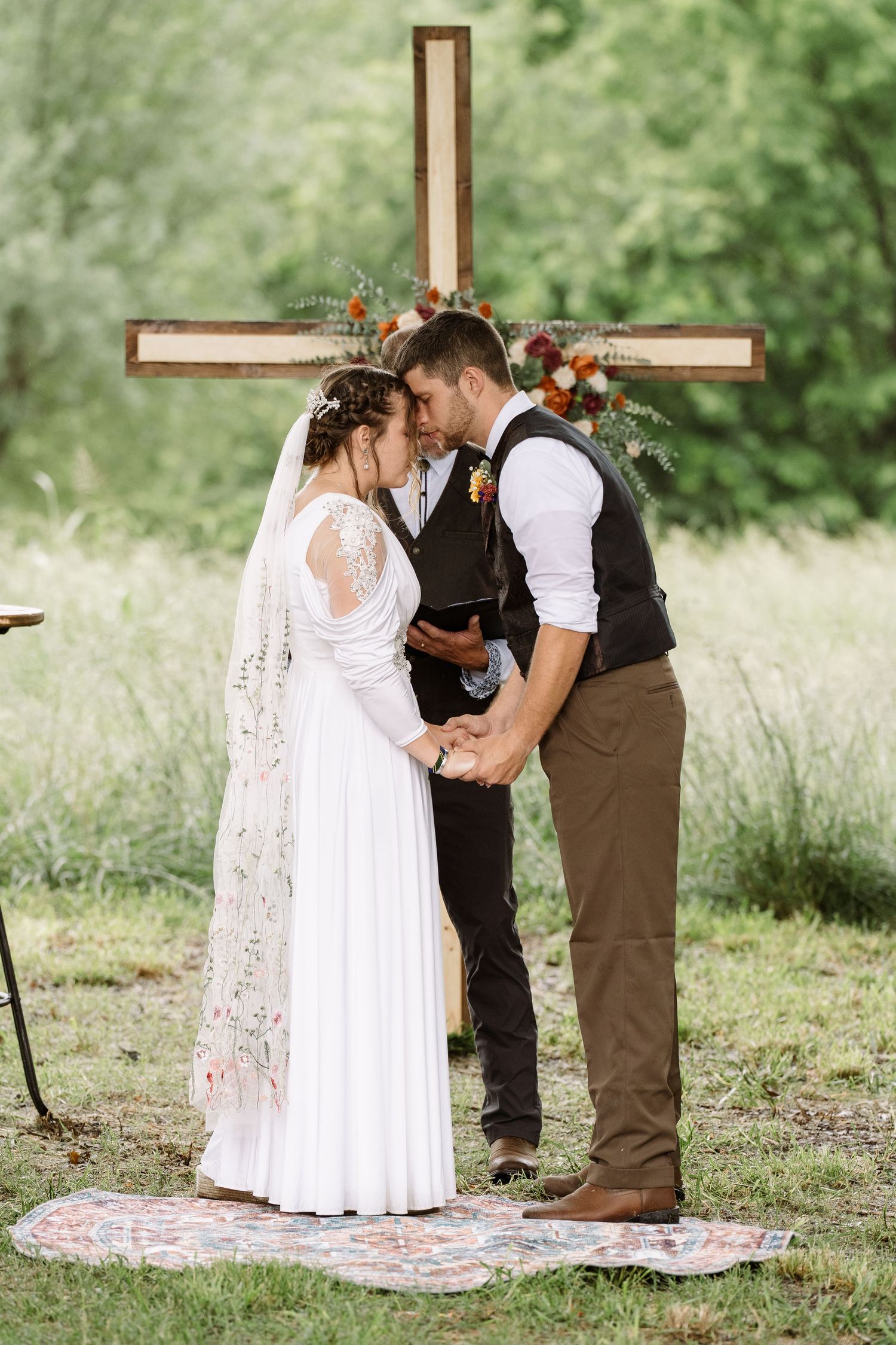 ©AnnaVonRiesenPhotography Wedding Photography | Color image of the bride & groom touching foreherads at the altar.