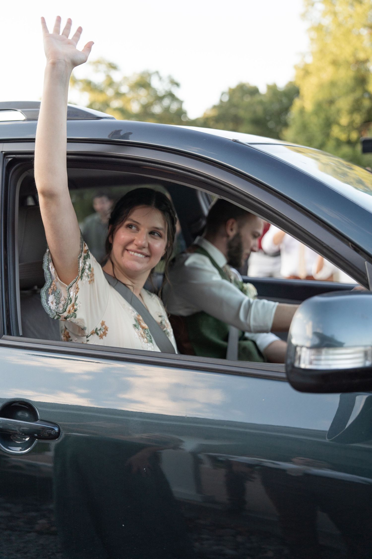 ©AnnaVonRiesenPhotography Wedding Photography | Color image of the bride waving 'goodbye' to her guests from the car.