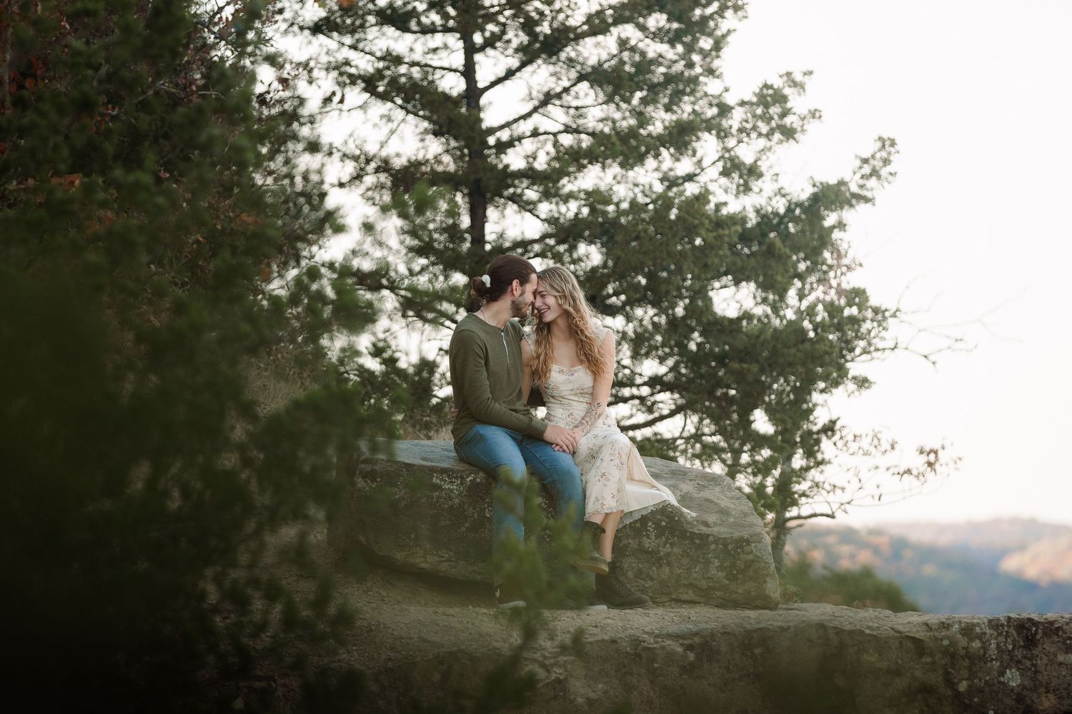 ©AnnaVonRiesenPhotography Couples Photography | Color image of a couple touching foreheads while sitting on a rock.