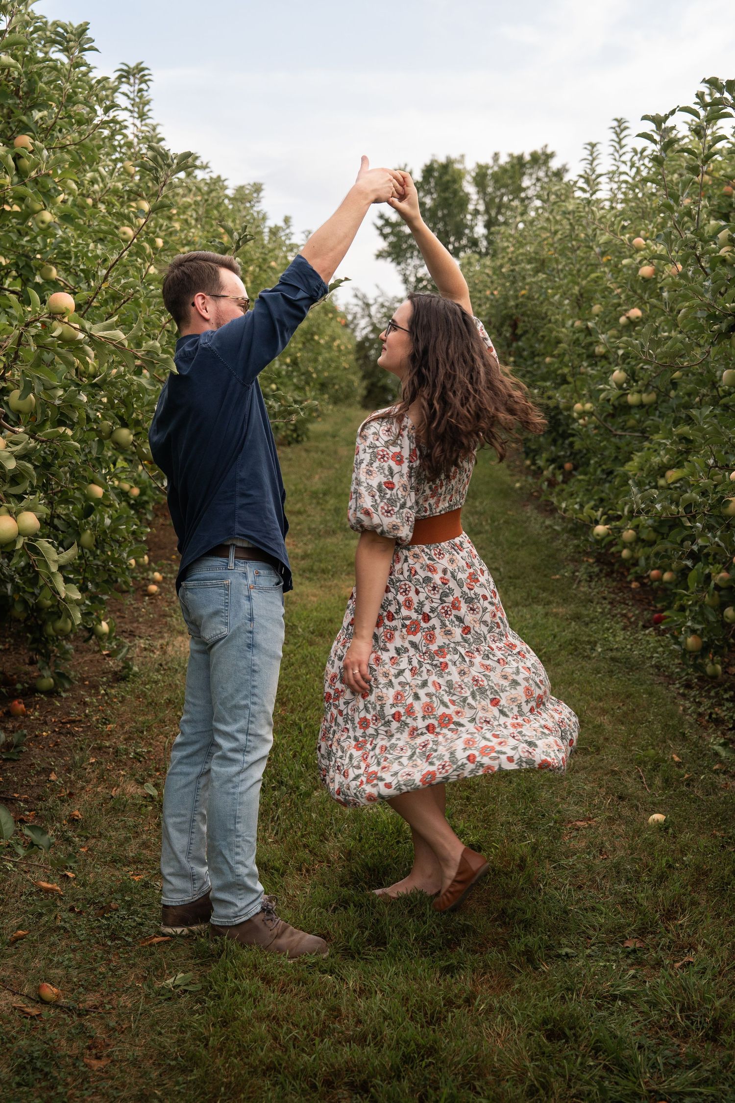 ©AnnaVonRiesenPhotography Couples Photography | Color image of a man twirling his wife while she smiles.
