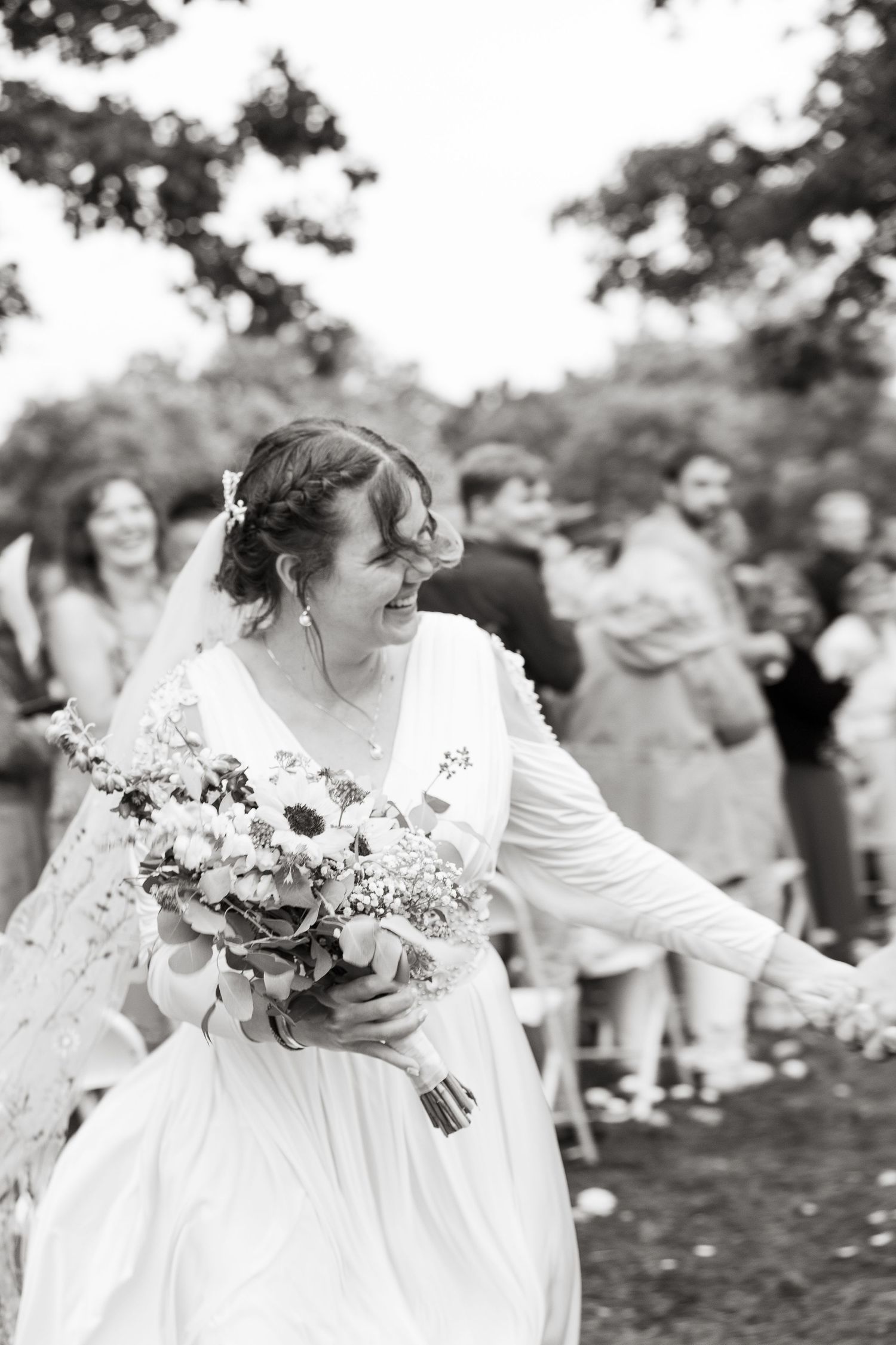 ©AnnaVonRiesenPhotography Wedding Photography | B&W image of a bride smiling while running down the aisle.