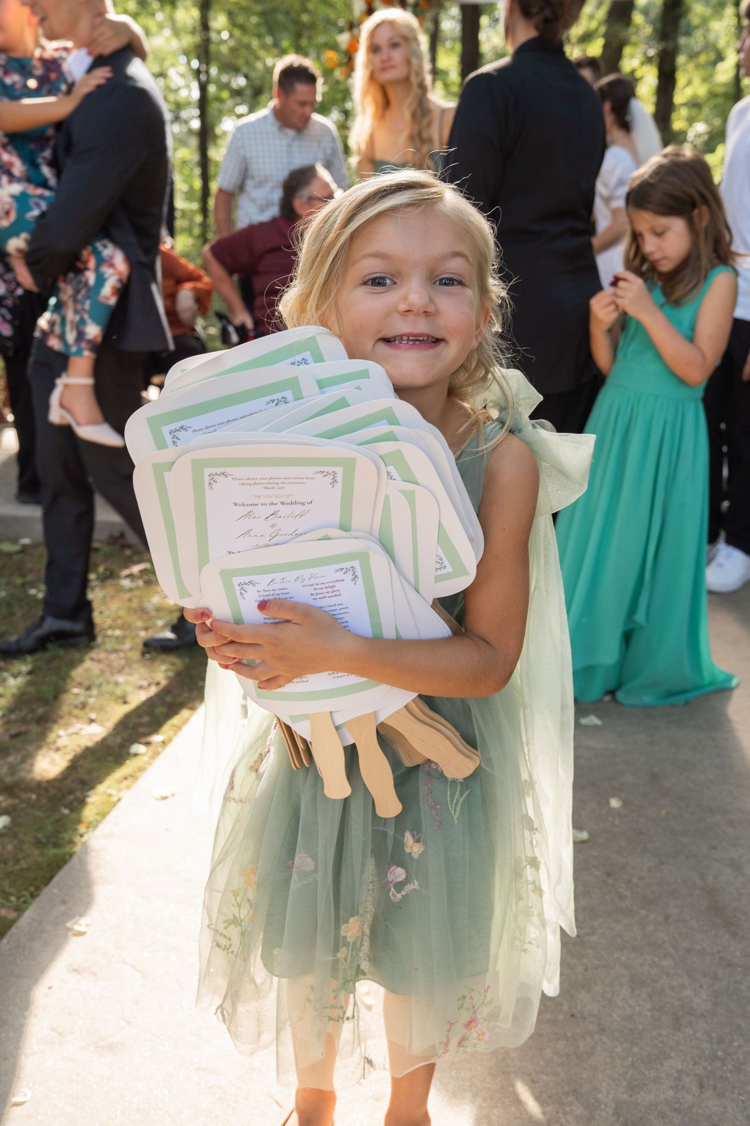 ©AnnaVonRiesenPhotography Wedding Photography | Color image of a flower girl collecting left-behind ceremony programs.