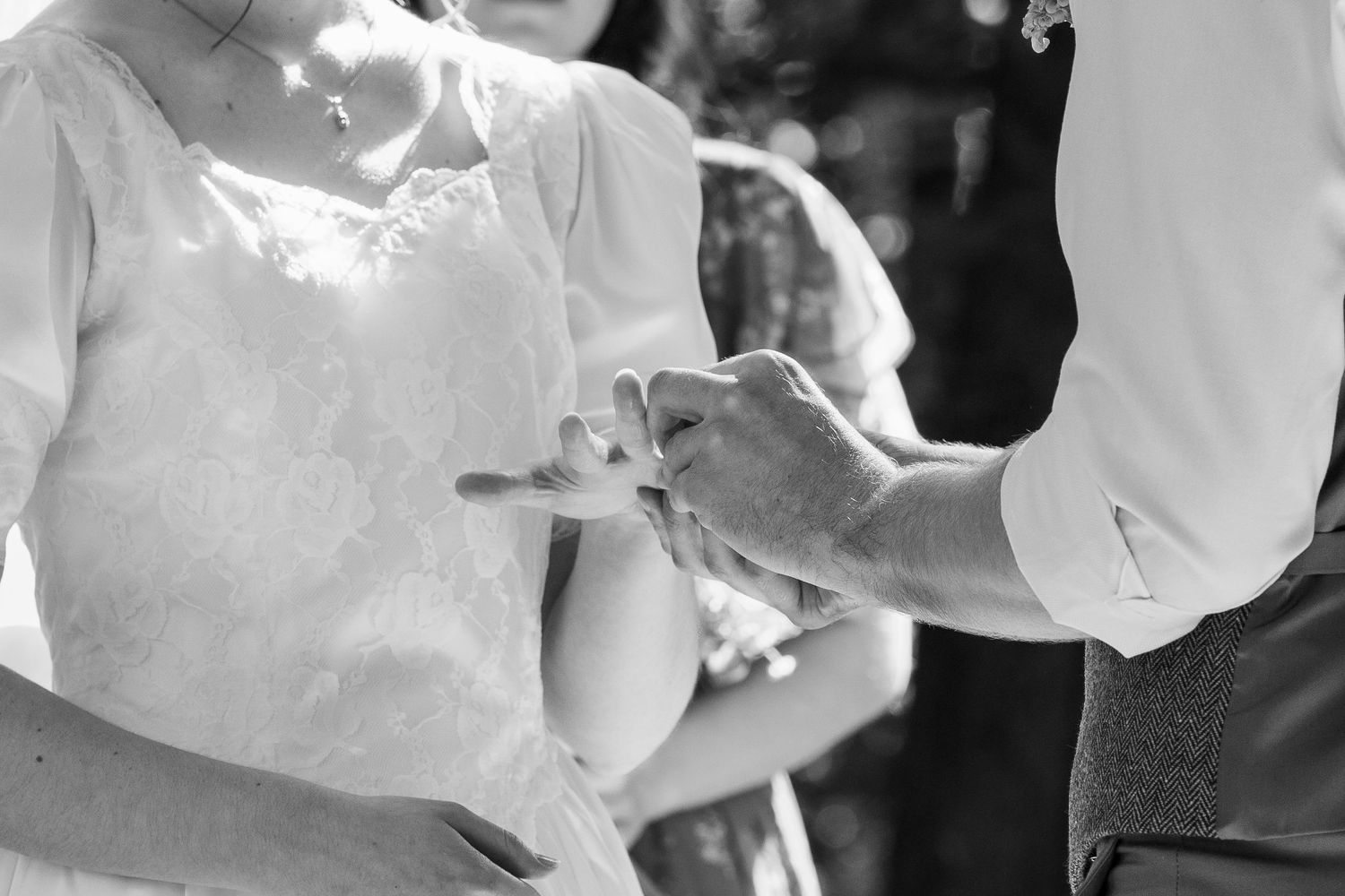 ©AnnaVonRiesenPhotography Wedding Photography | B&W image of the groom placing a ring on the bride's finger.