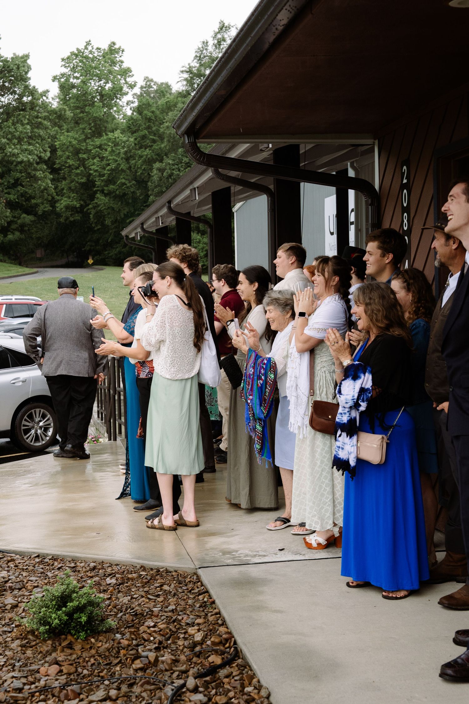 ©AnnaVonRiesenPhotography Wedding Photography | Color image of wedding guests gathered to watch the bride & groom arrive.