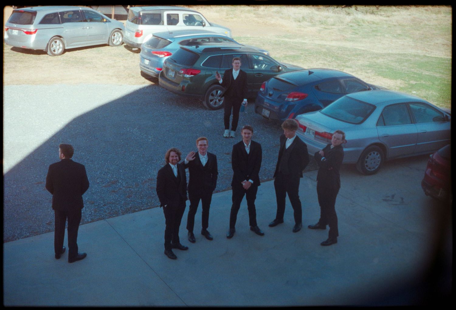 ©AnnaVonRiesenPhotography Wedding Photography | Film Color image of the groom and groomsmen through and upstairs window.