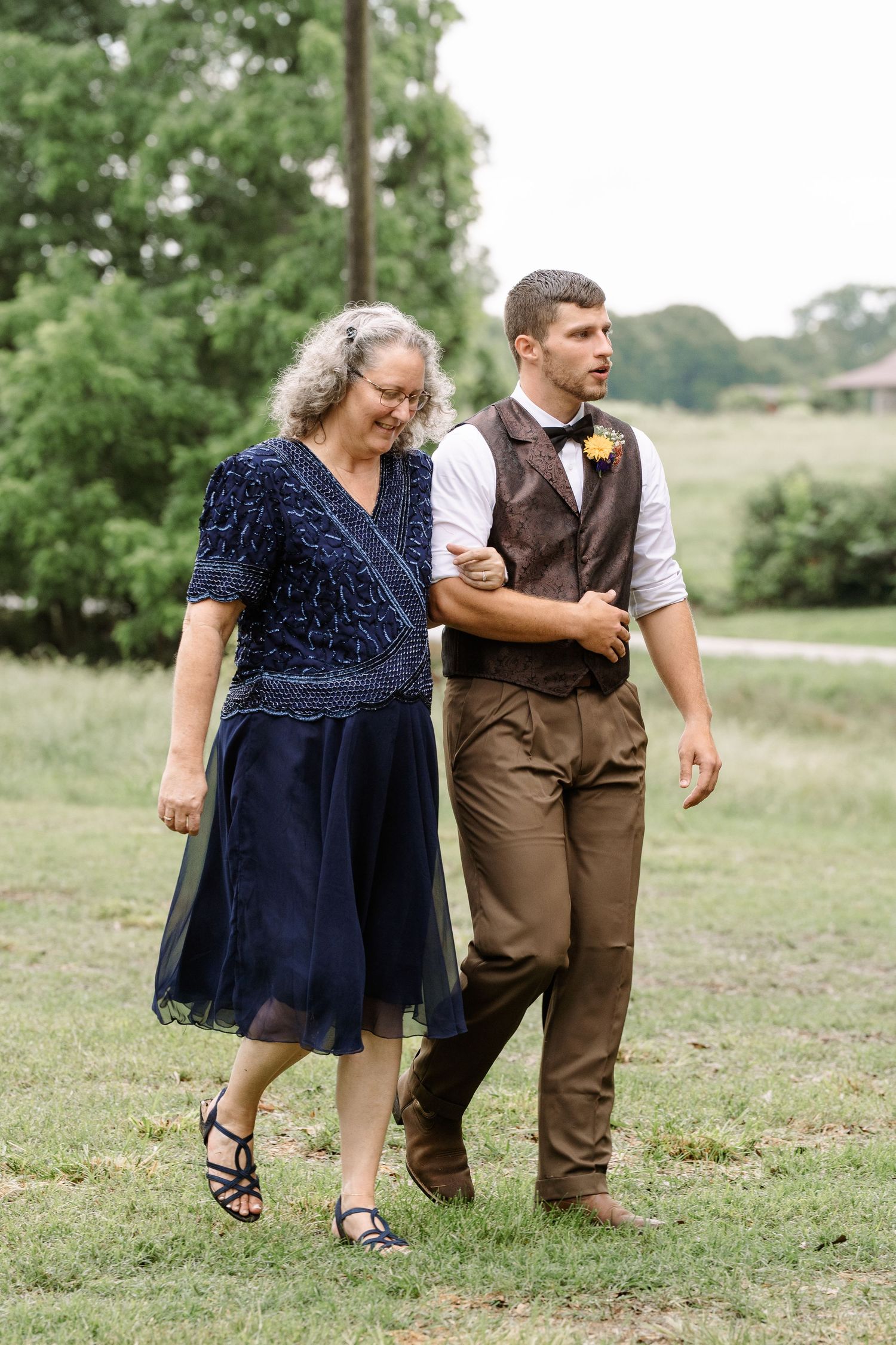 ©AnnaVonRiesenPhotography Wedding Photography | Color image of the groom walking with his mother down the aisle.