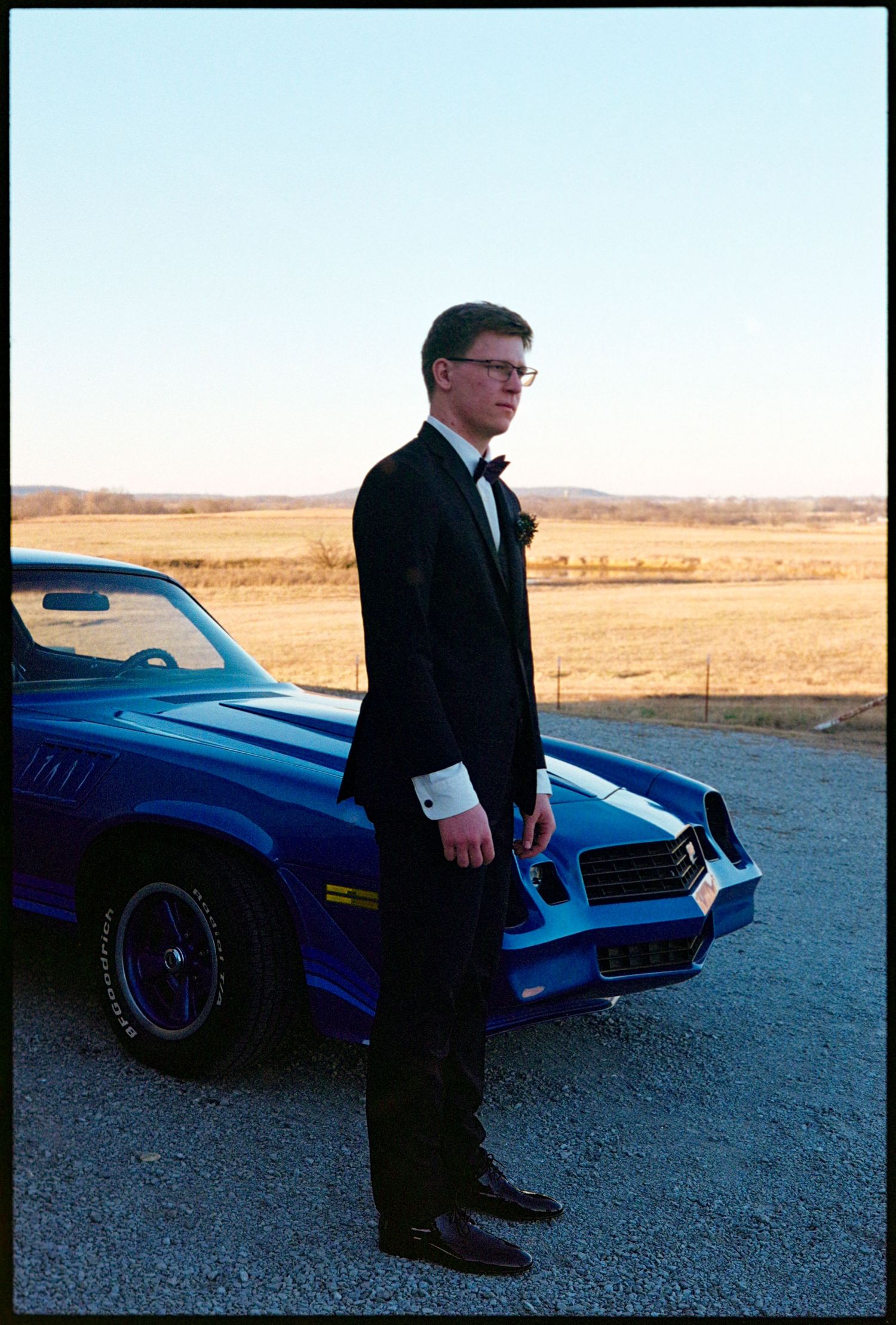 ©AnnaVonRiesenPhotography Wedding Photography | Film Color image of the groom posing in front of a cool car.
