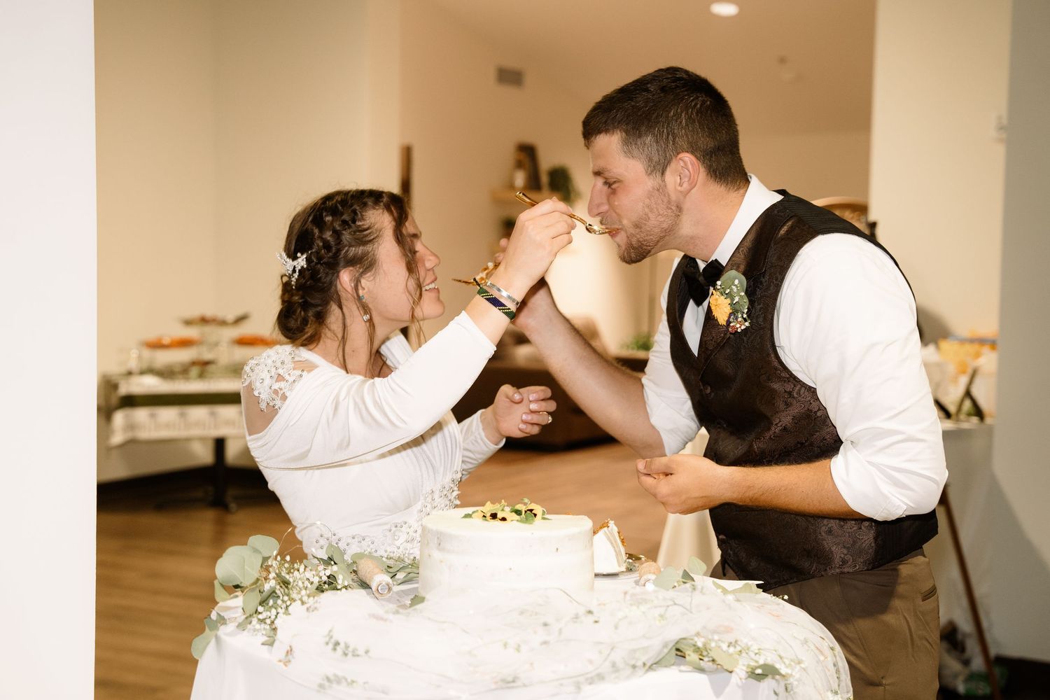 ©AnnaVonRiesenPhotography Wedding Photography | Color image of the bride & groom feeding eachother cake.