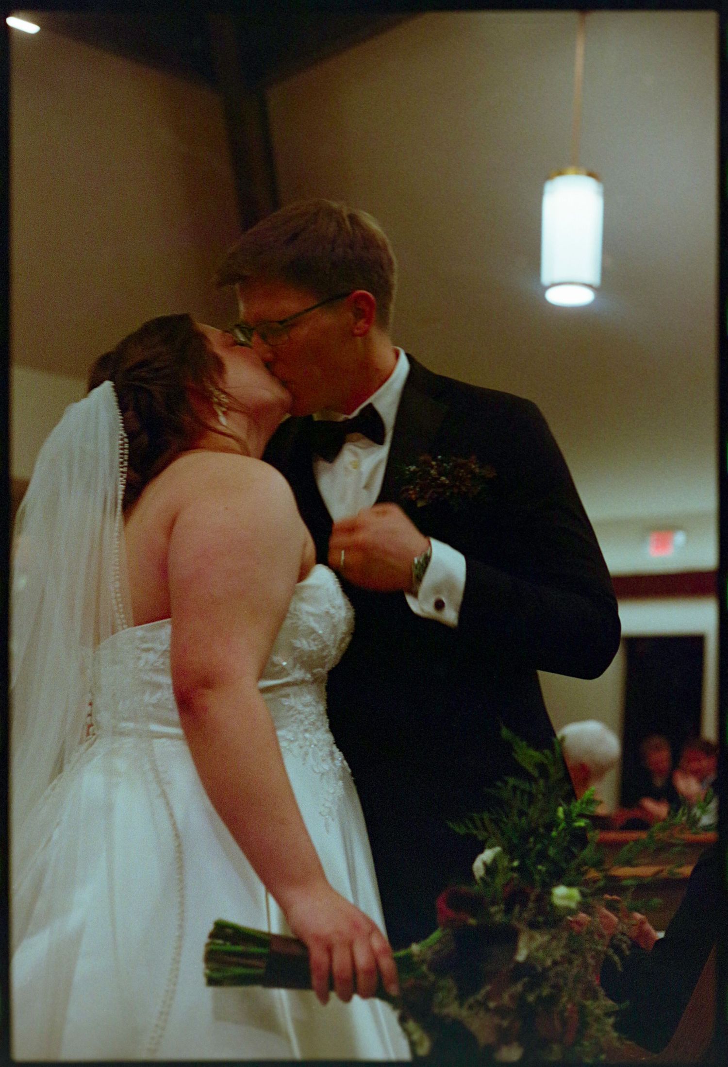 ©AnnaVonRiesenPhotography Wedding Photography | Film Color image of the bride and groom kissing in the aisle.