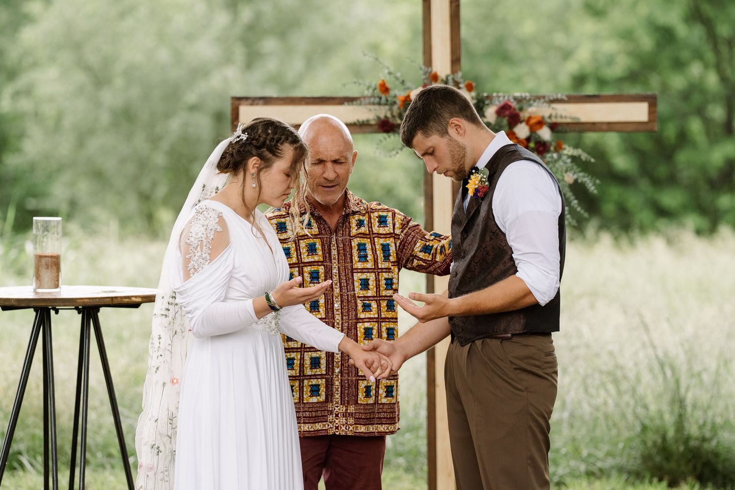 ©AnnaVonRiesenPhotography Wedding Photography | Color image of the bride's family friend praying over them at the altar.