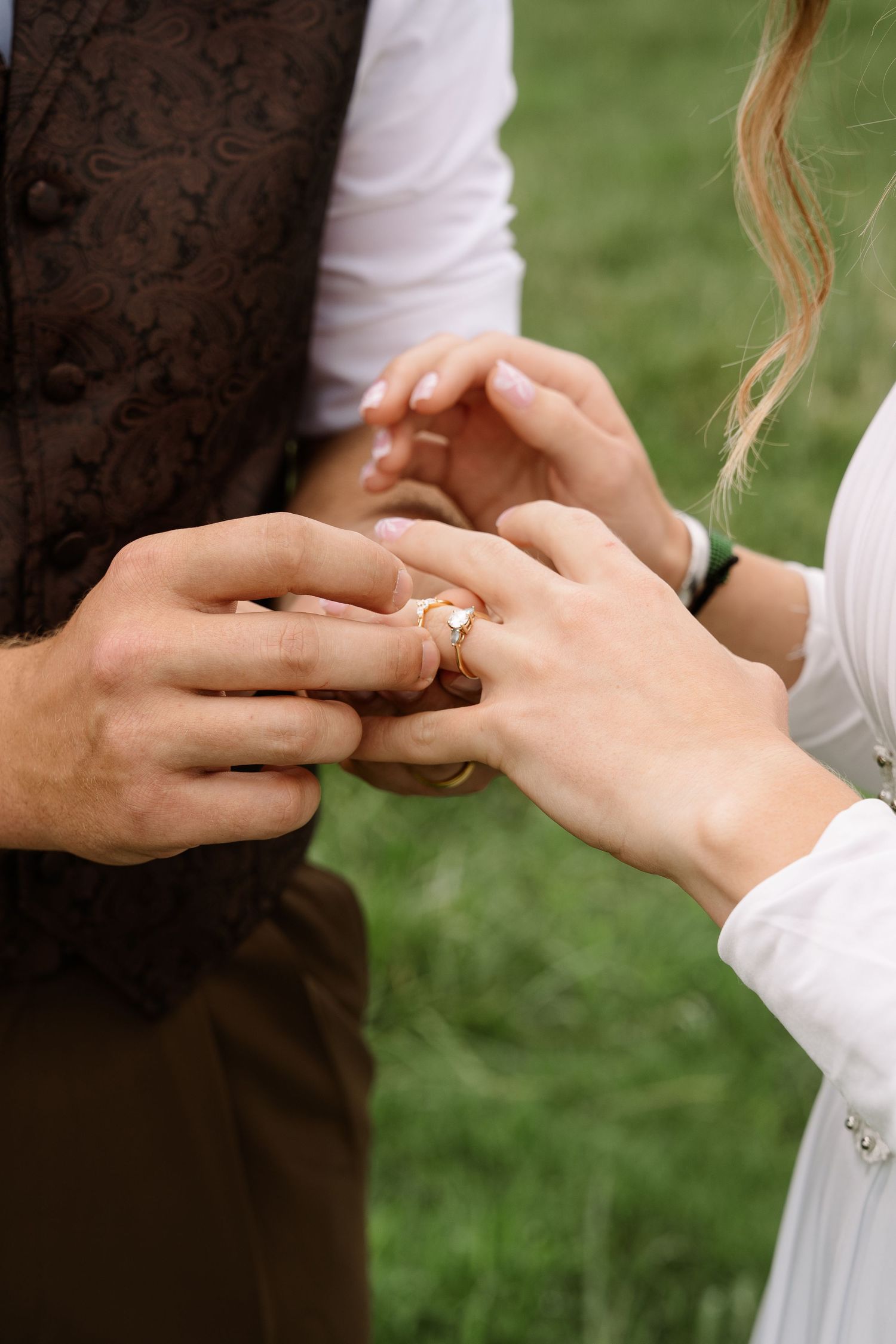©AnnaVonRiesenPhotography Wedding Photography | Color image of the groom placing a ring on his bride.