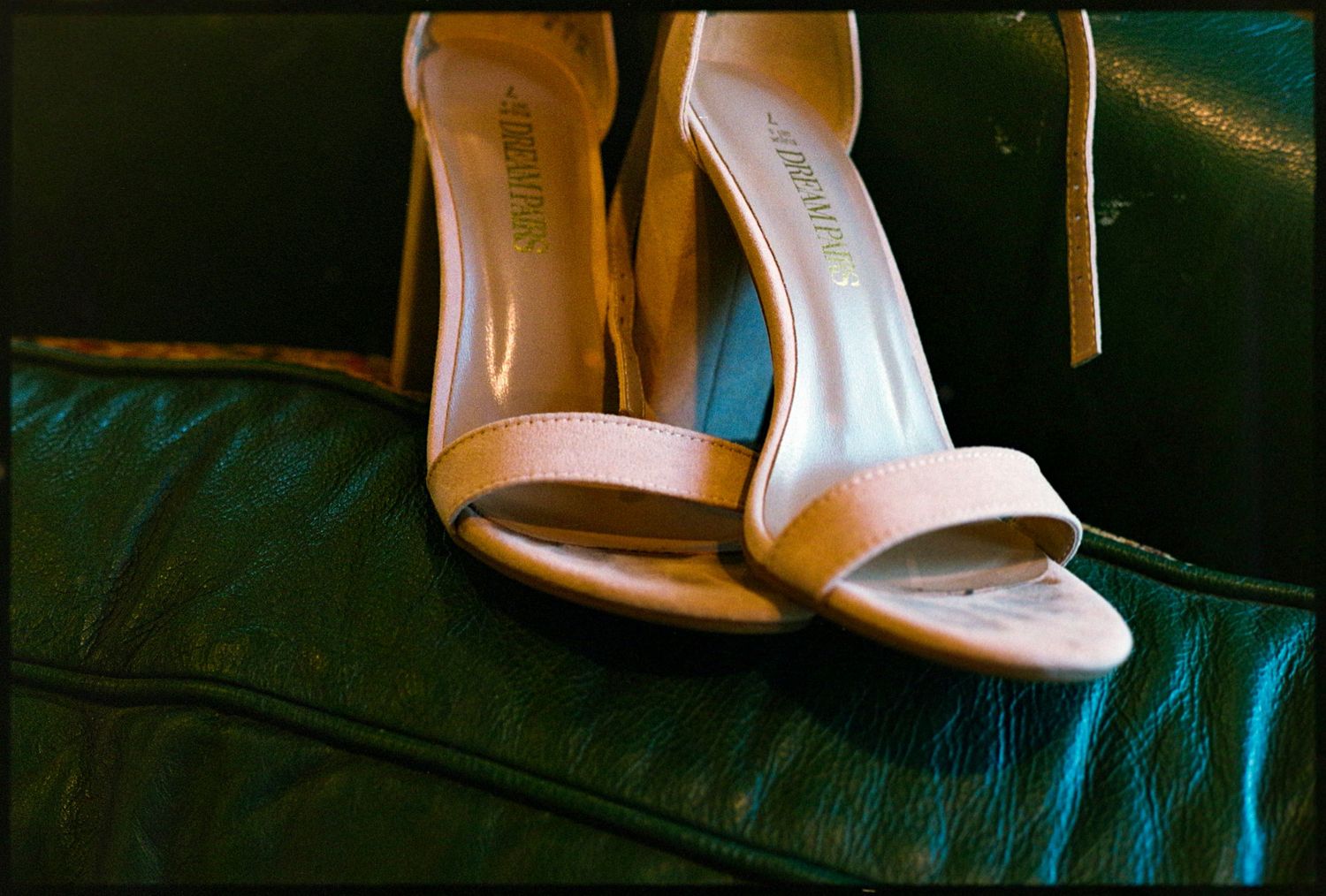 ©AnnaVonRiesenPhotography Wedding Photography | Film Color image of high heel shoes against a green couch.