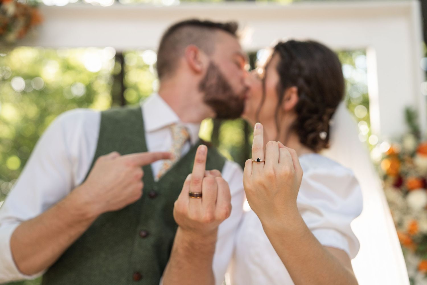 ©AnnaVonRiesenPhotography Wedding Photography | Color image of the bride & groom kissing and holding their ring fingers up to the camera.