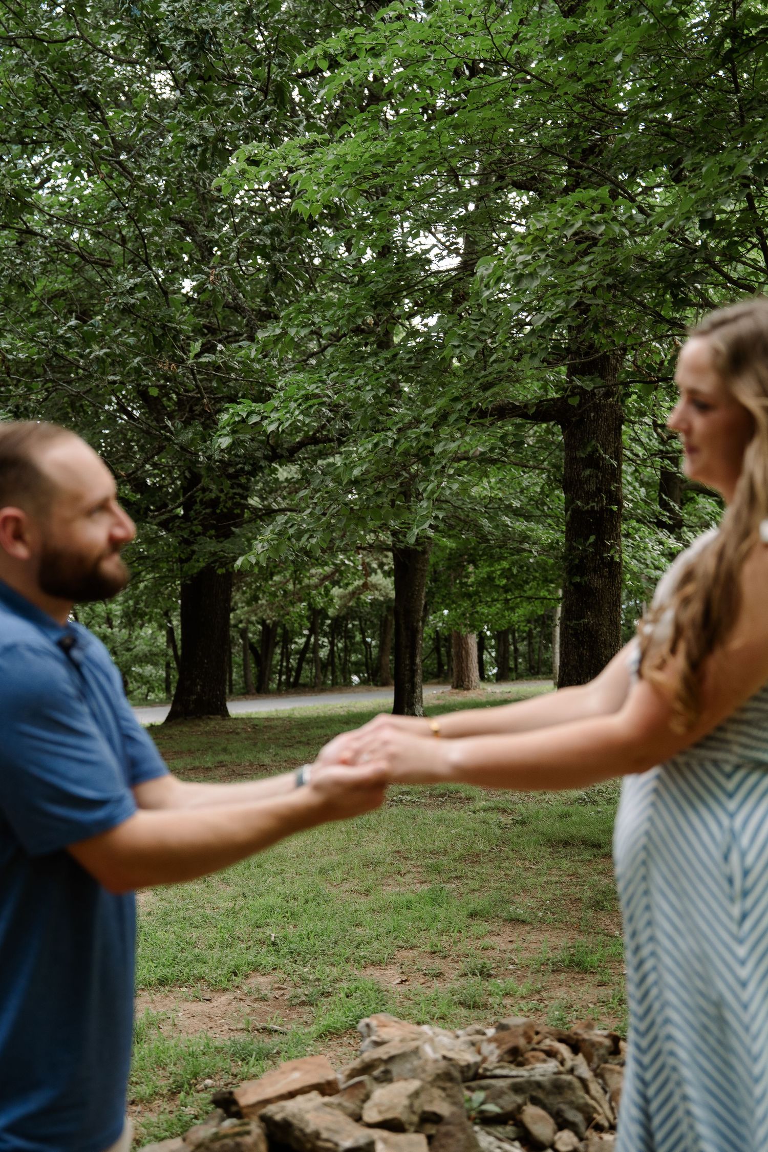 ©AnnaVonRiesenPhotography Engagement Photography | Color image of a couple holding hands, the trees in the background are in focus.