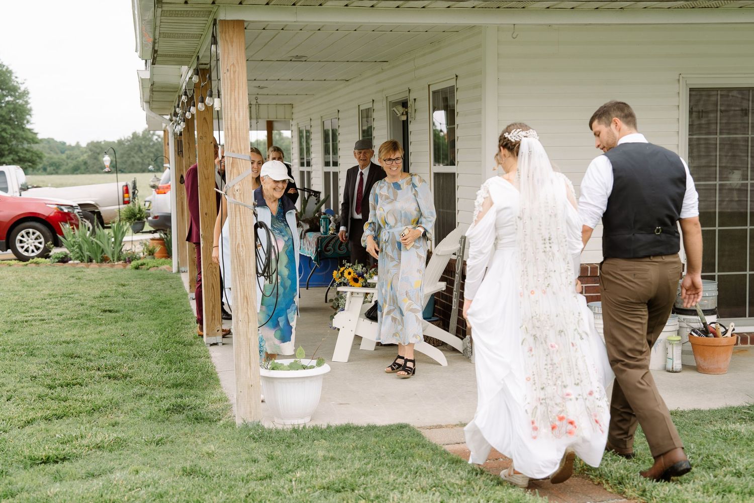 ©AnnaVonRiesenPhotography Wedding Photography | Color image of the bride & groom walking towards their family.