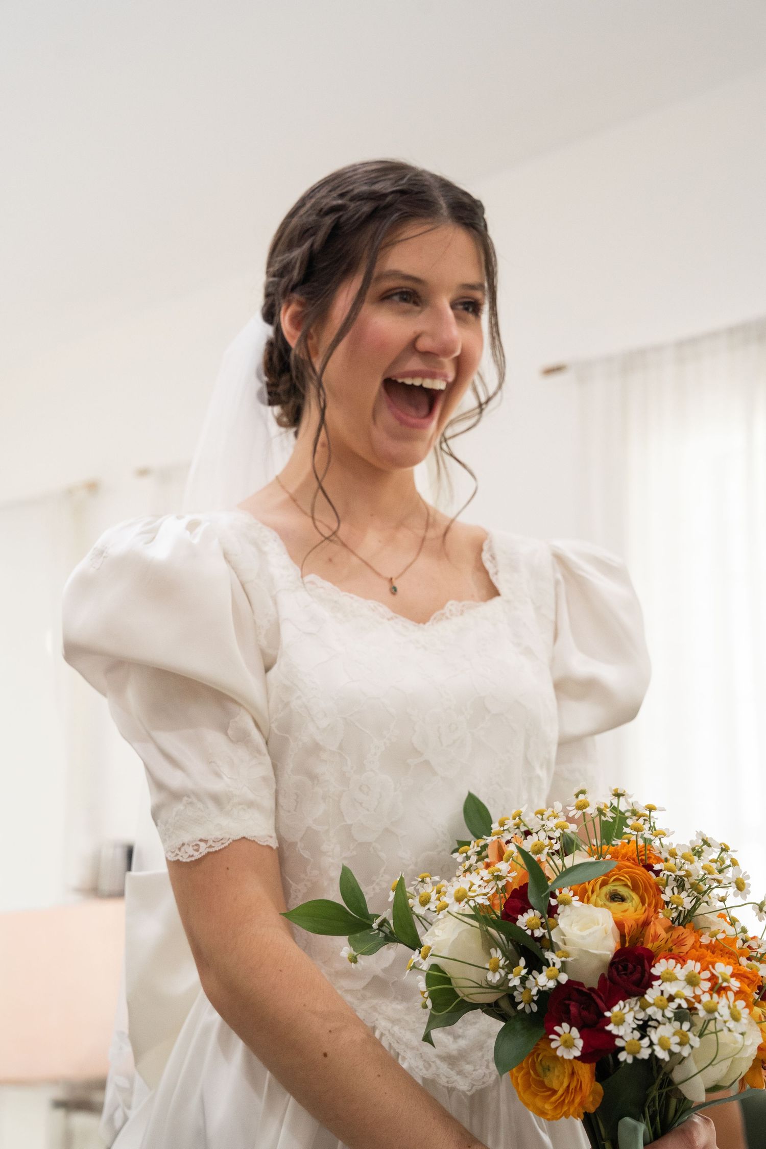 ©AnnaVonRiesenPhotography Wedding Photography | Color image of the bride reacting to her wedding outfit in the mirror.