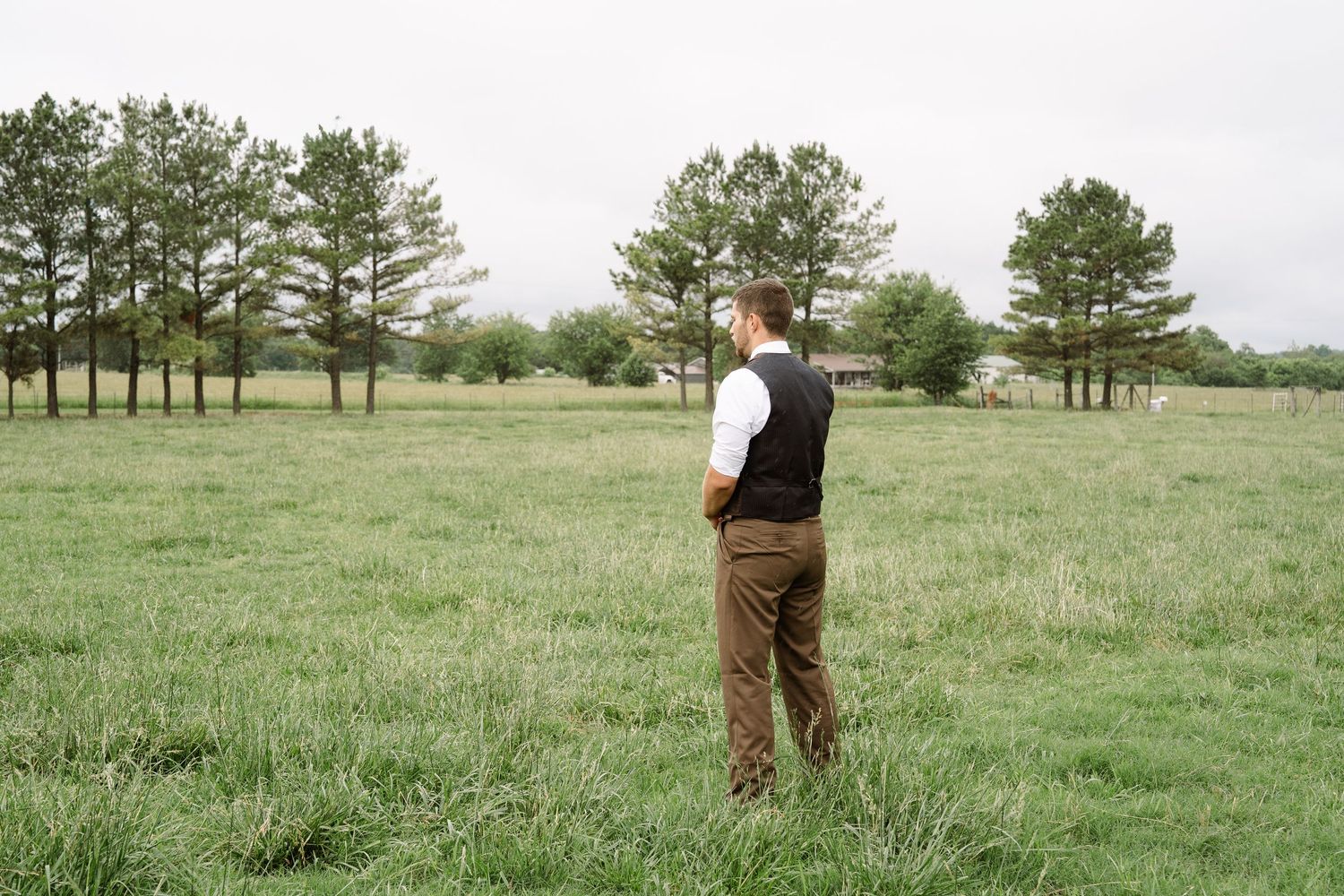 ©AnnaVonRiesenPhotography Wedding Photography | Color image of the groom standing in a field waiting for his bride.