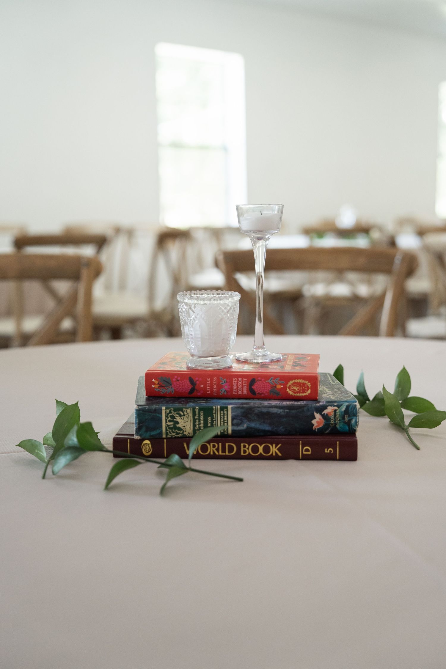 ©AnnaVonRiesenPhotography Wedding Photography | Color image of reception decor, candles, books, greenery.