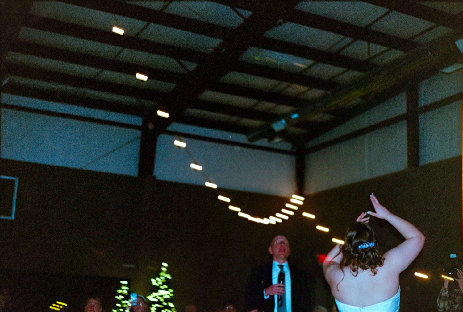©AnnaVonRiesenPhotography Wedding Photography | Film Color image of the bride tossing her bouquet behind her.