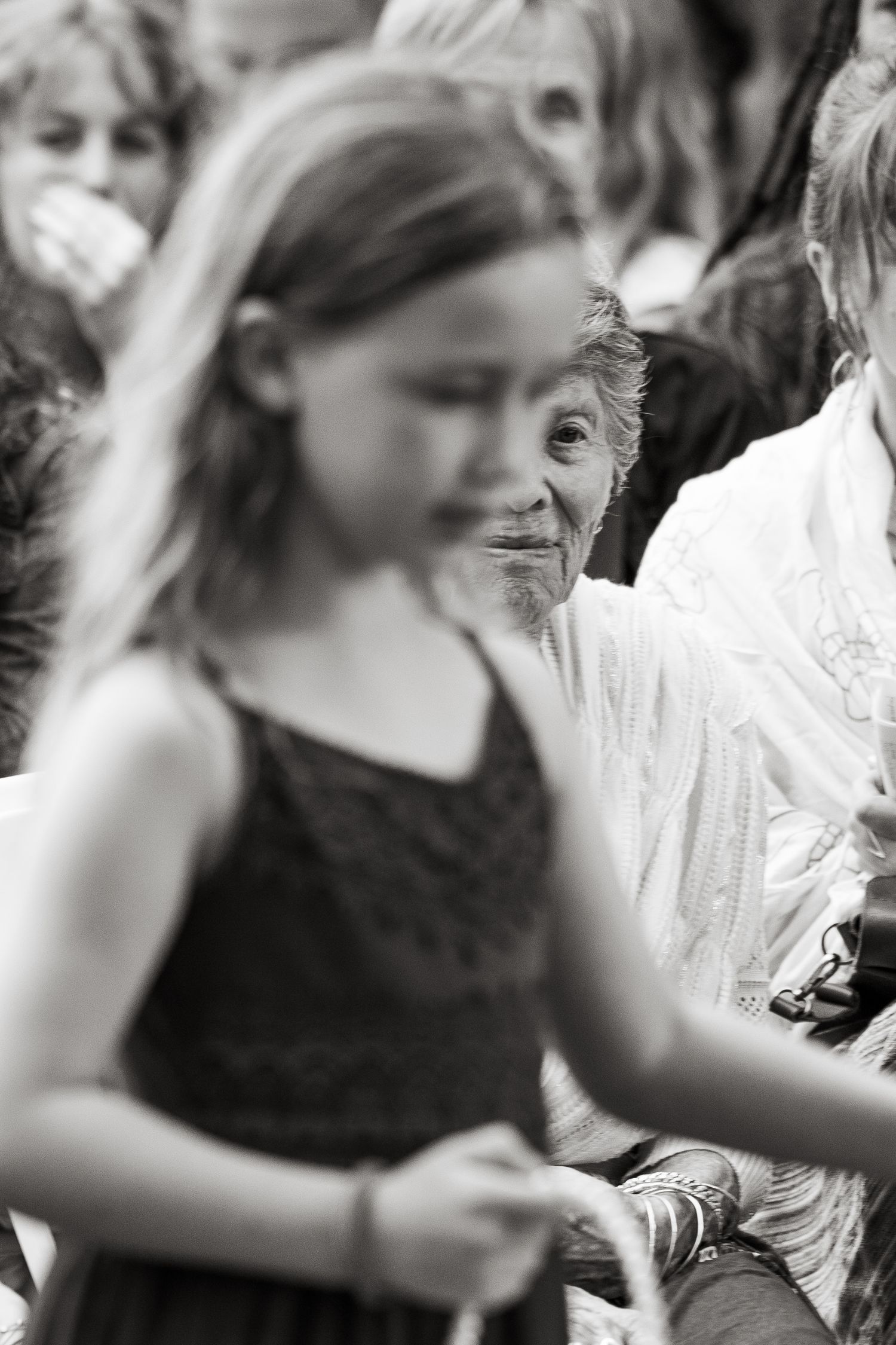 ©AnnaVonRiesenPhotography Wedding Photography | B&W image of an older wedding guest watching the flower girl walk down the aisle.