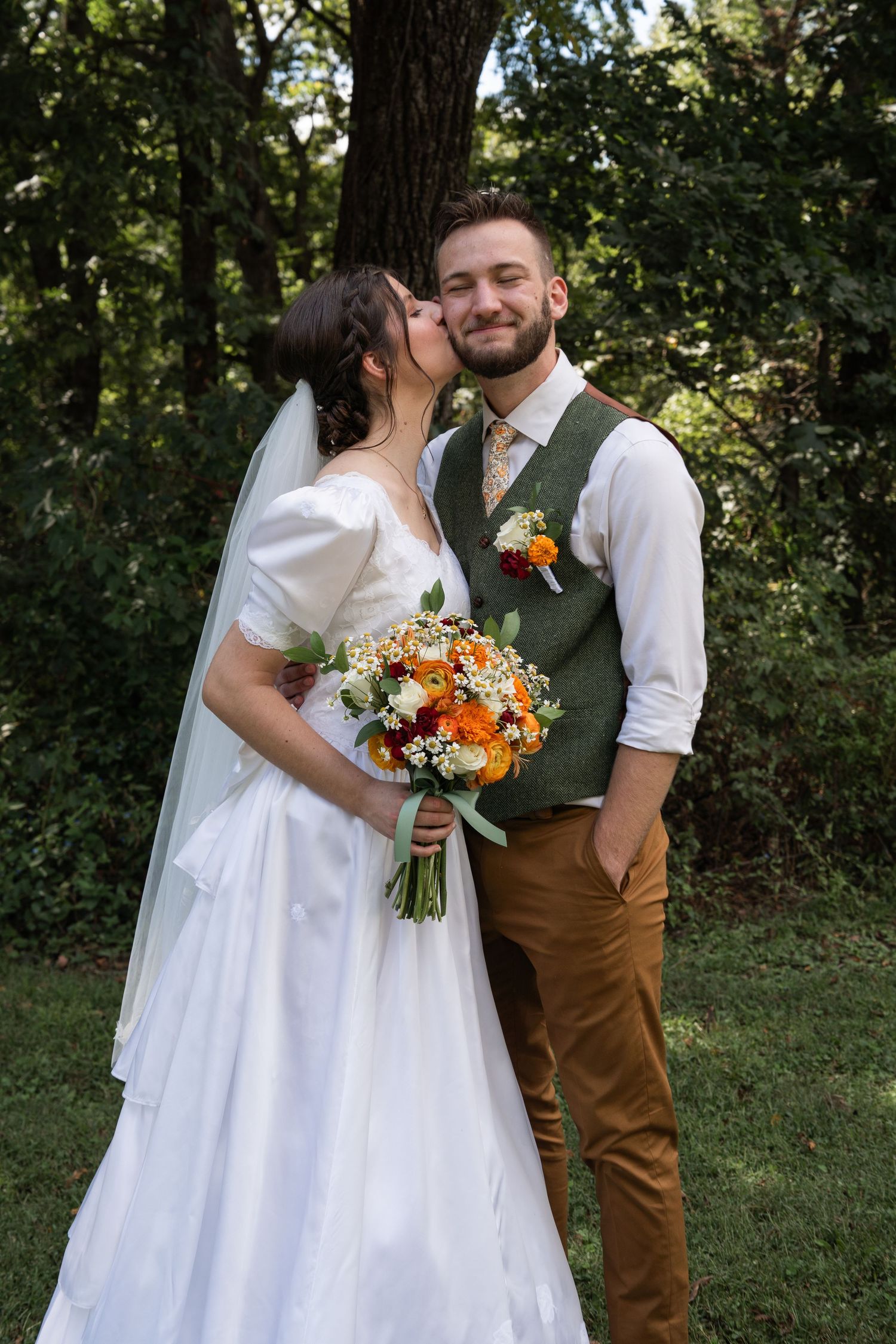 ©AnnaVonRiesenPhotography Wedding Photography | Color image of the bride giving her groom a kiss on the cheek.