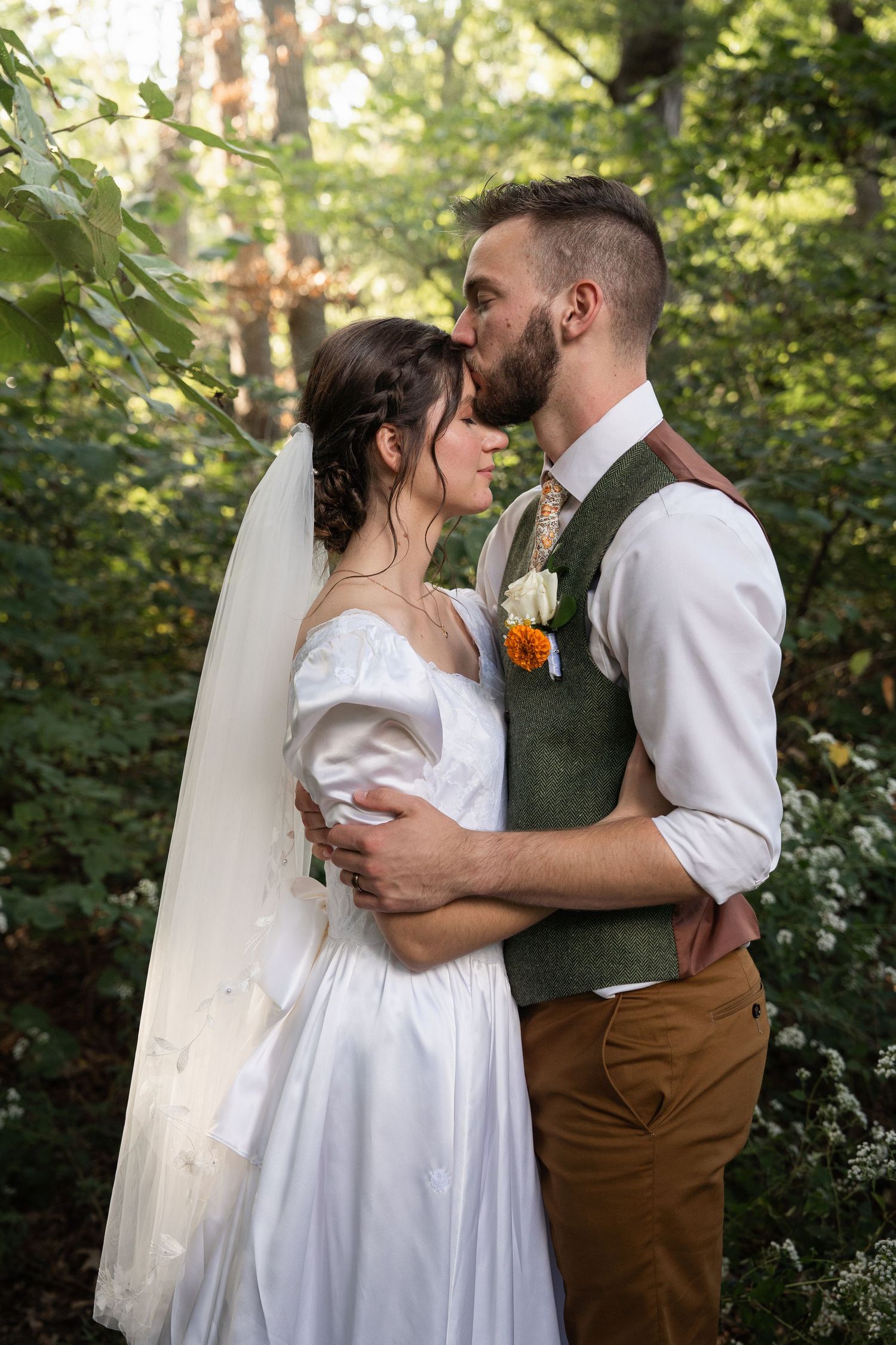 ©AnnaVonRiesenPhotography Wedding Photography | Color image of the groom kissing his bride on the forehead.