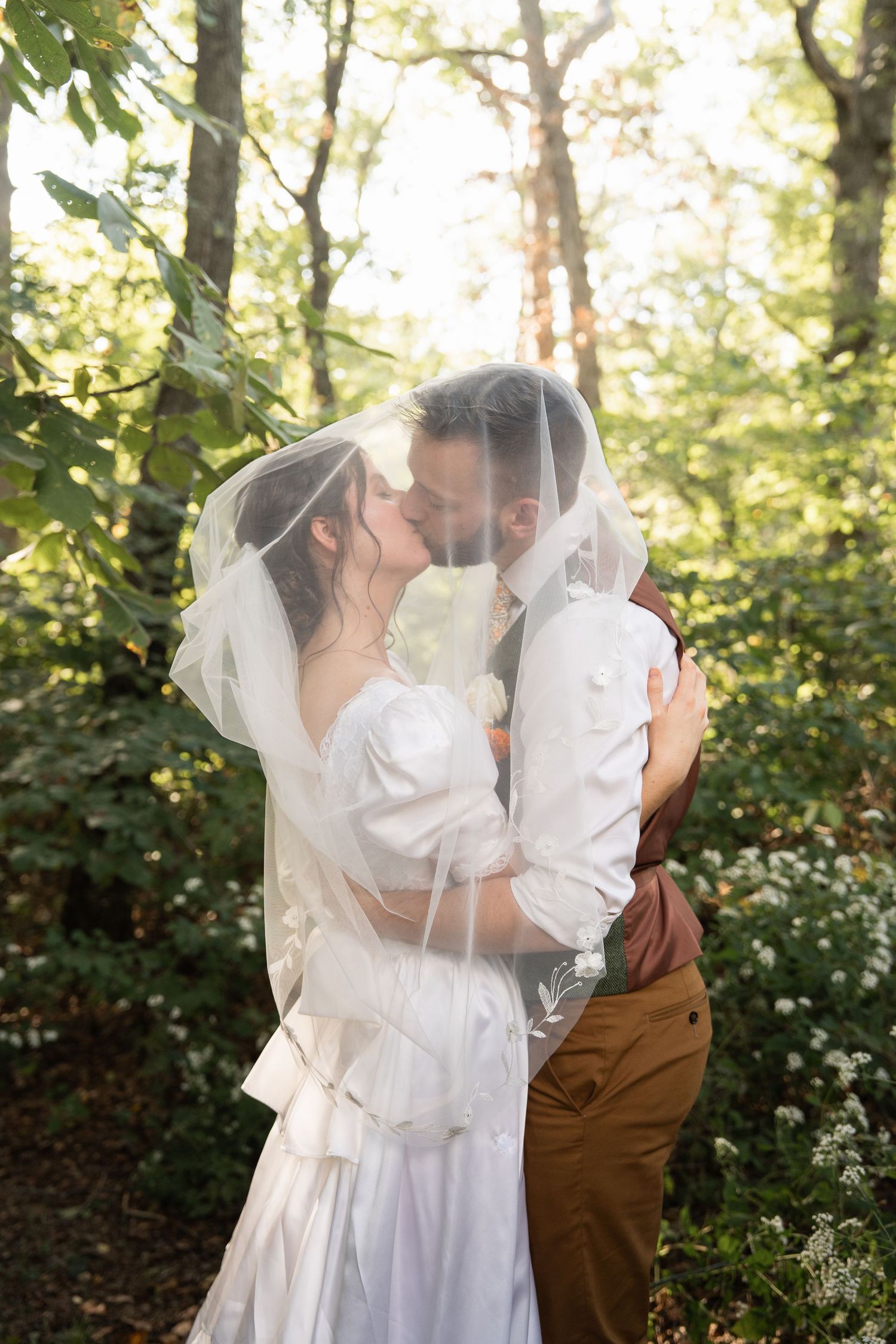 ©AnnaVonRiesenPhotography Wedding Photography | Color image of the bride & groom kissing under the veil.
