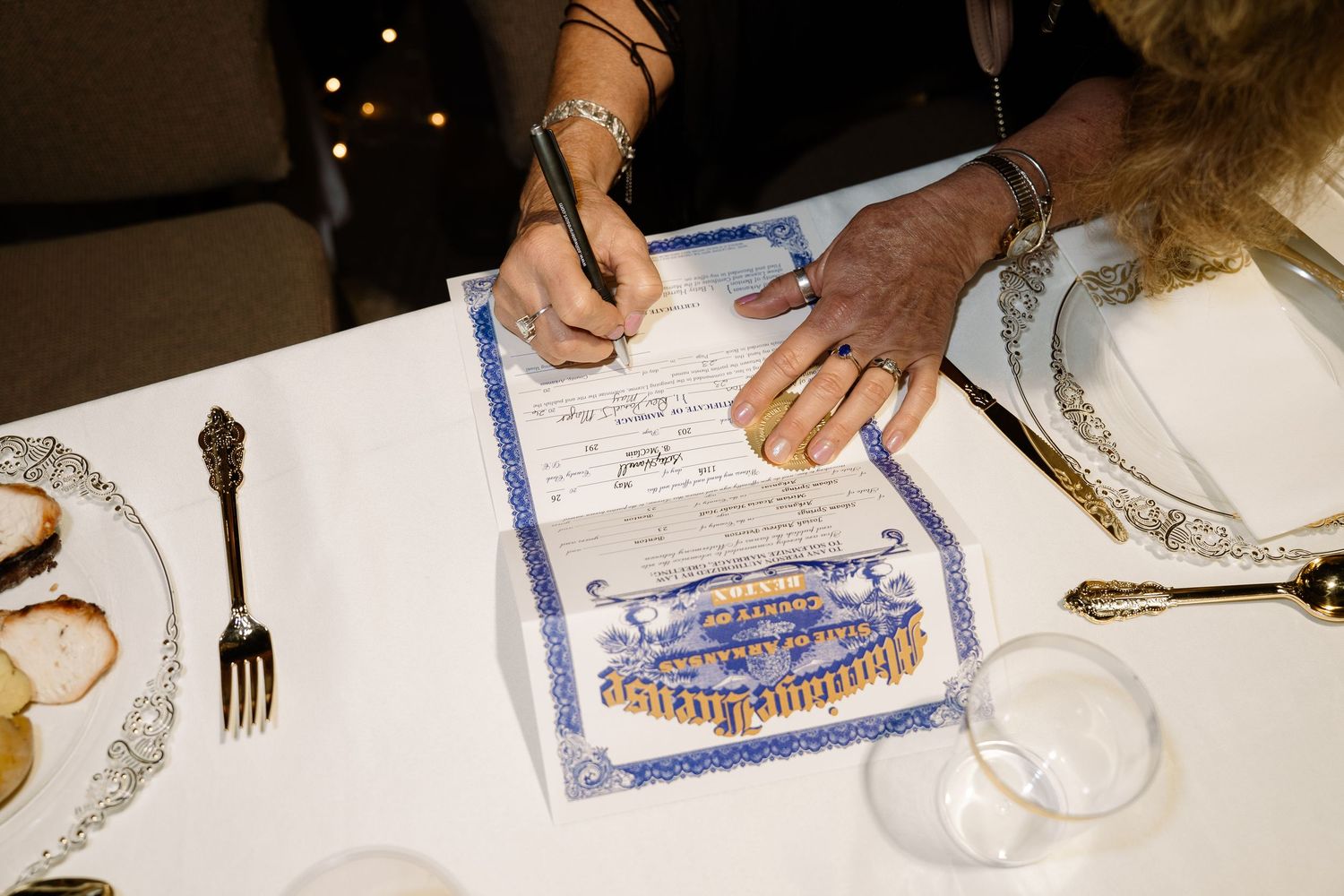 ©AnnaVonRiesenPhotography Wedding Photography | Color image of the marriage license being signed.