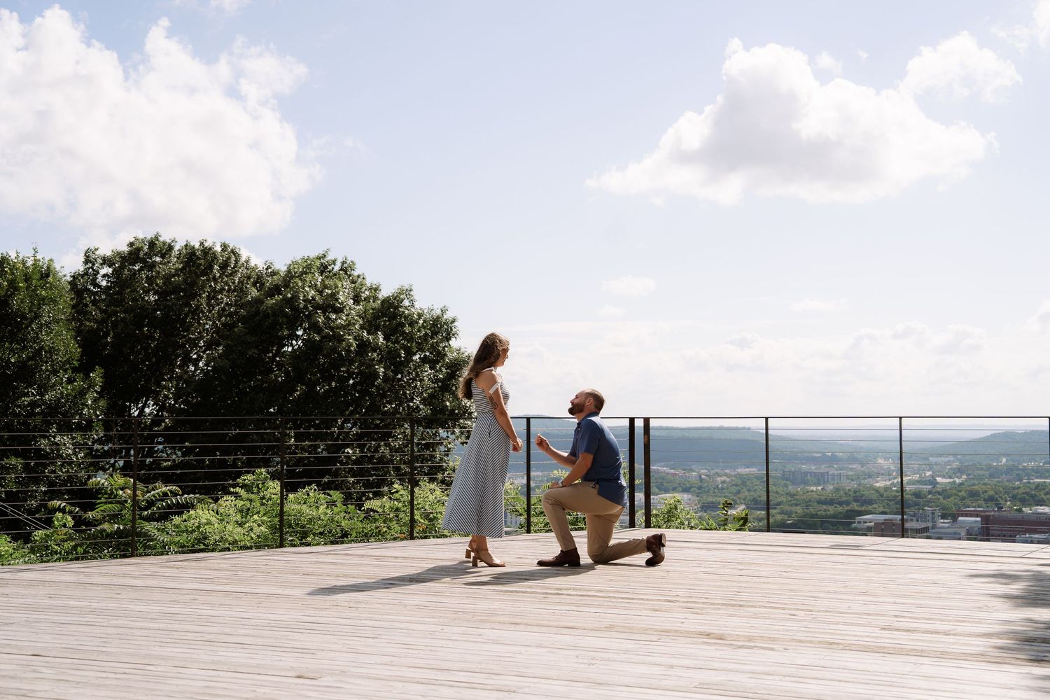 ©AnnaVonRiesenPhotography Wedding Photography | Color image of a man proposing to his girlfriend overlooking a cityscape.