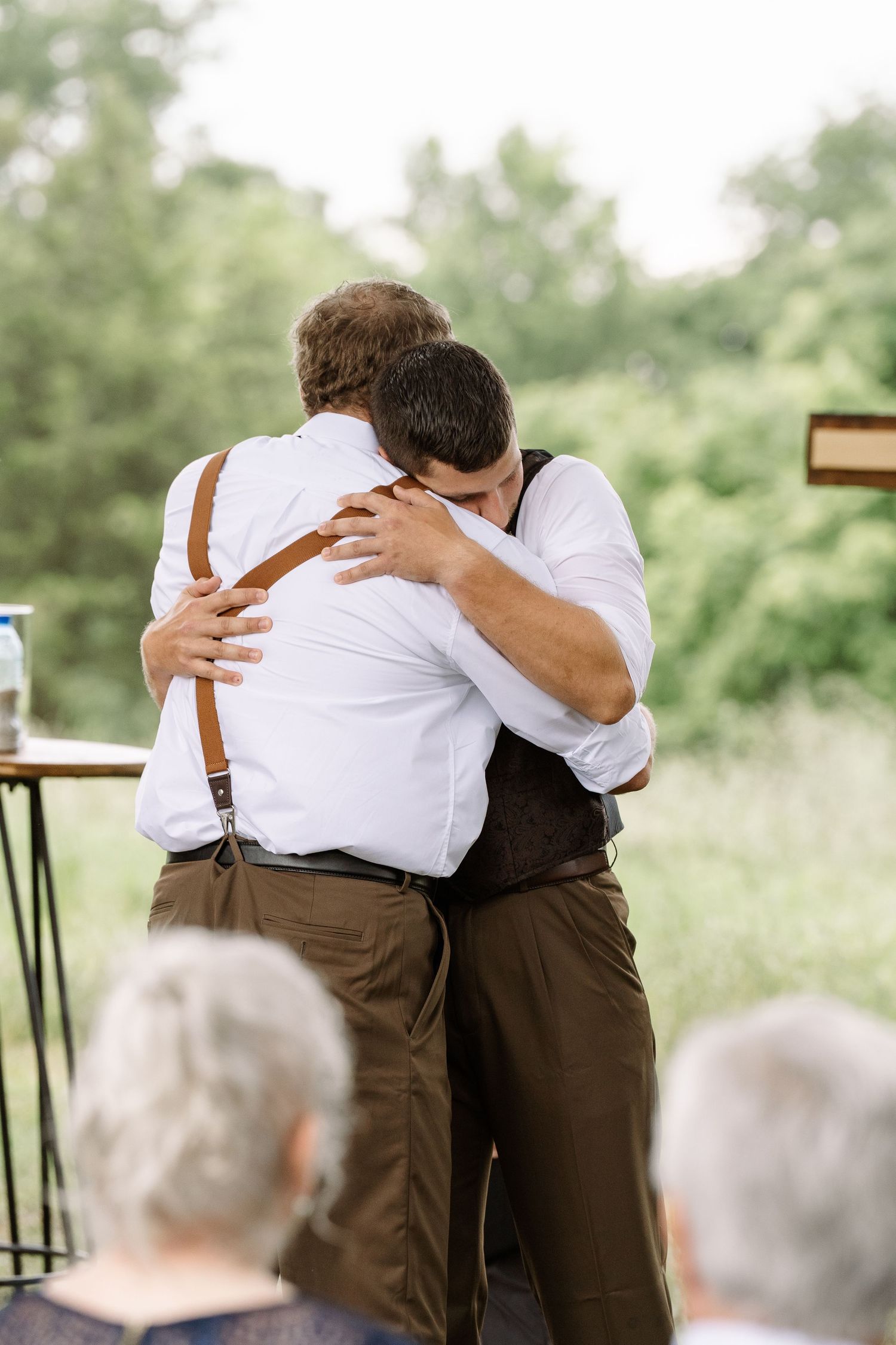 ©AnnaVonRiesenPhotography Wedding Photography | Color image of the groom hugging his groomsman.