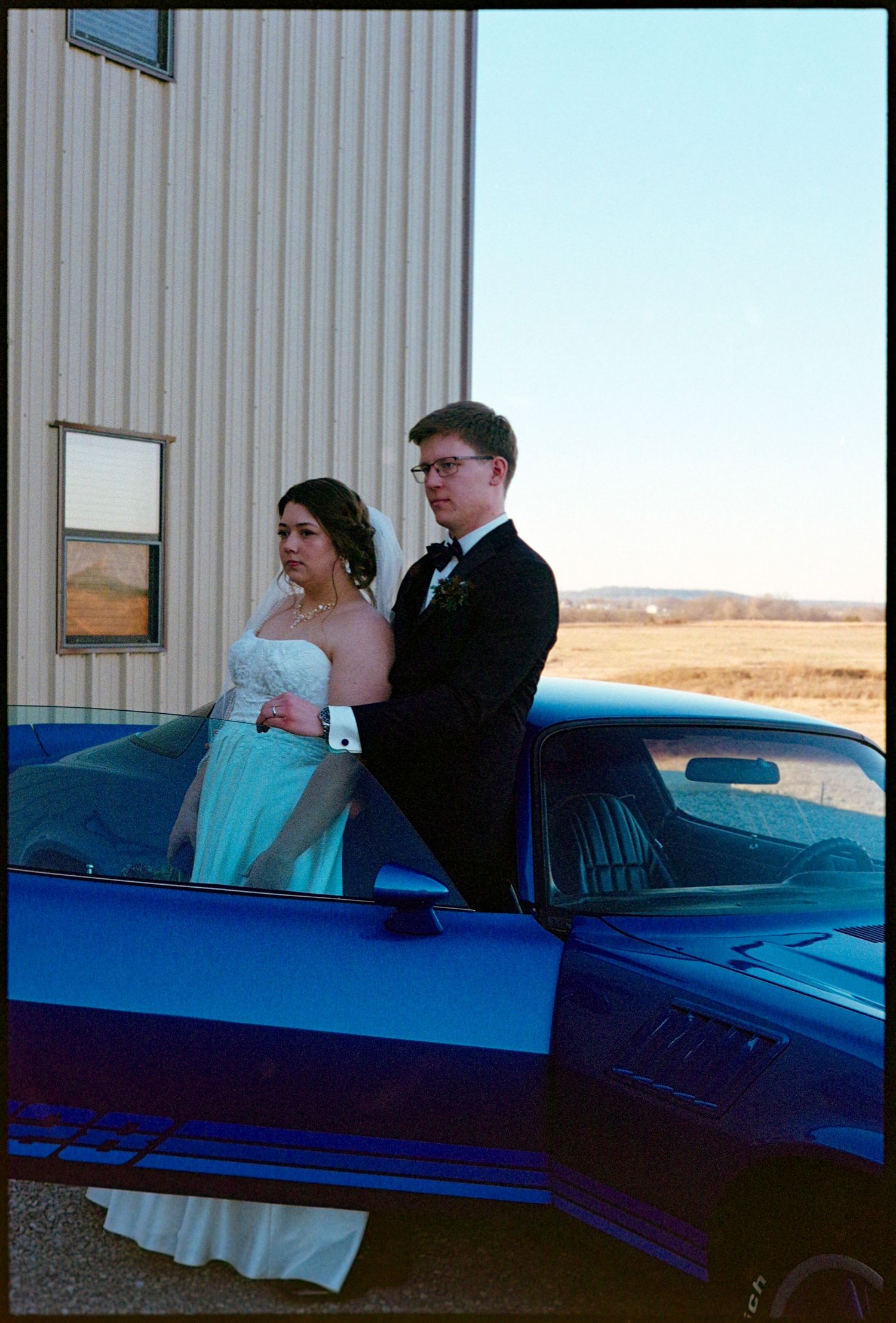 ©AnnaVonRiesenPhotography Wedding Photography | Film Color image of the bride & groom with a cool car.