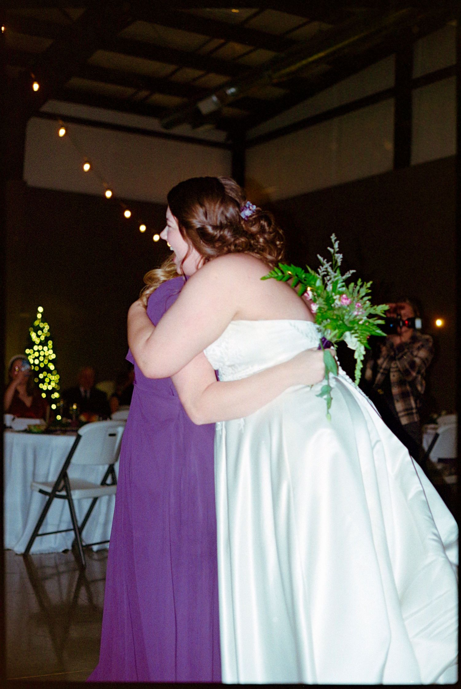 ©AnnaVonRiesenPhotography Wedding Photography | Film Color image of the bride hugging her friend who caught the bouquet.