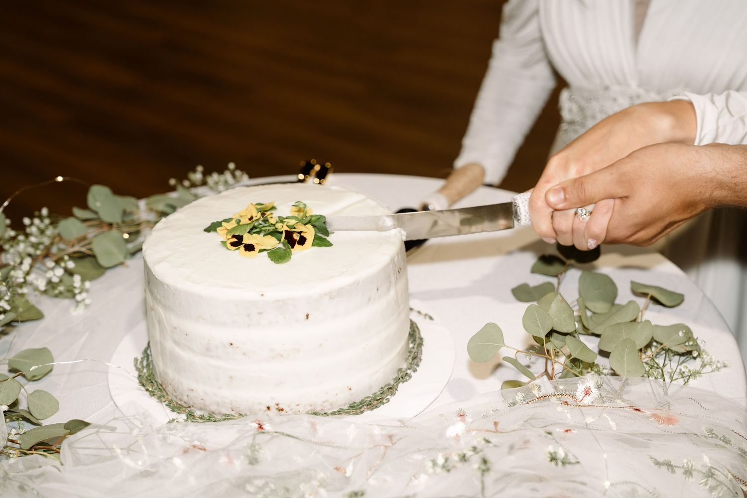 ©AnnaVonRiesenPhotography Wedding Photography | Color image of the cake being cut by the bride & groom.