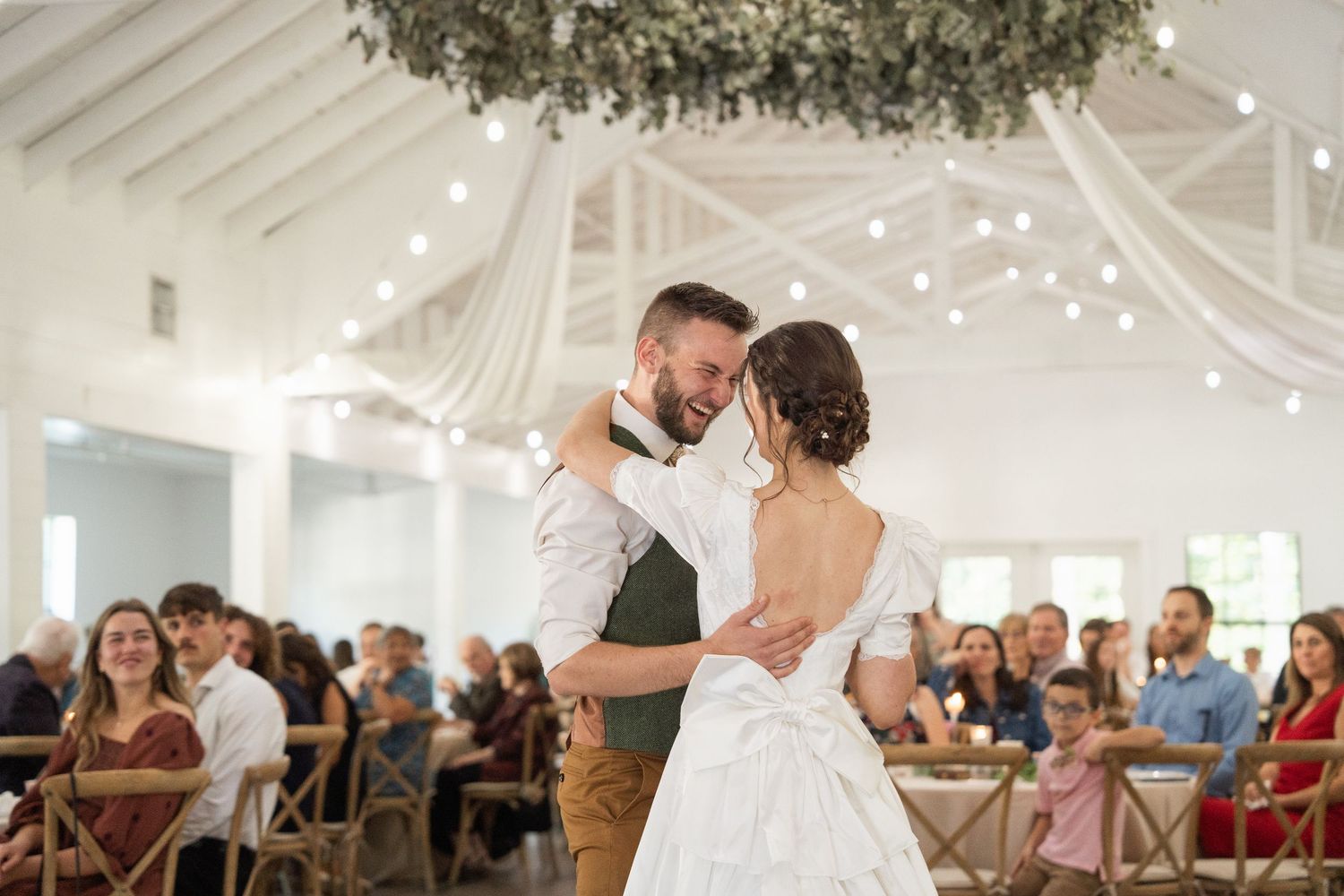 ©AnnaVonRiesenPhotography Wedding Photography |  Color image of a bride & groom smiling & dancing together.