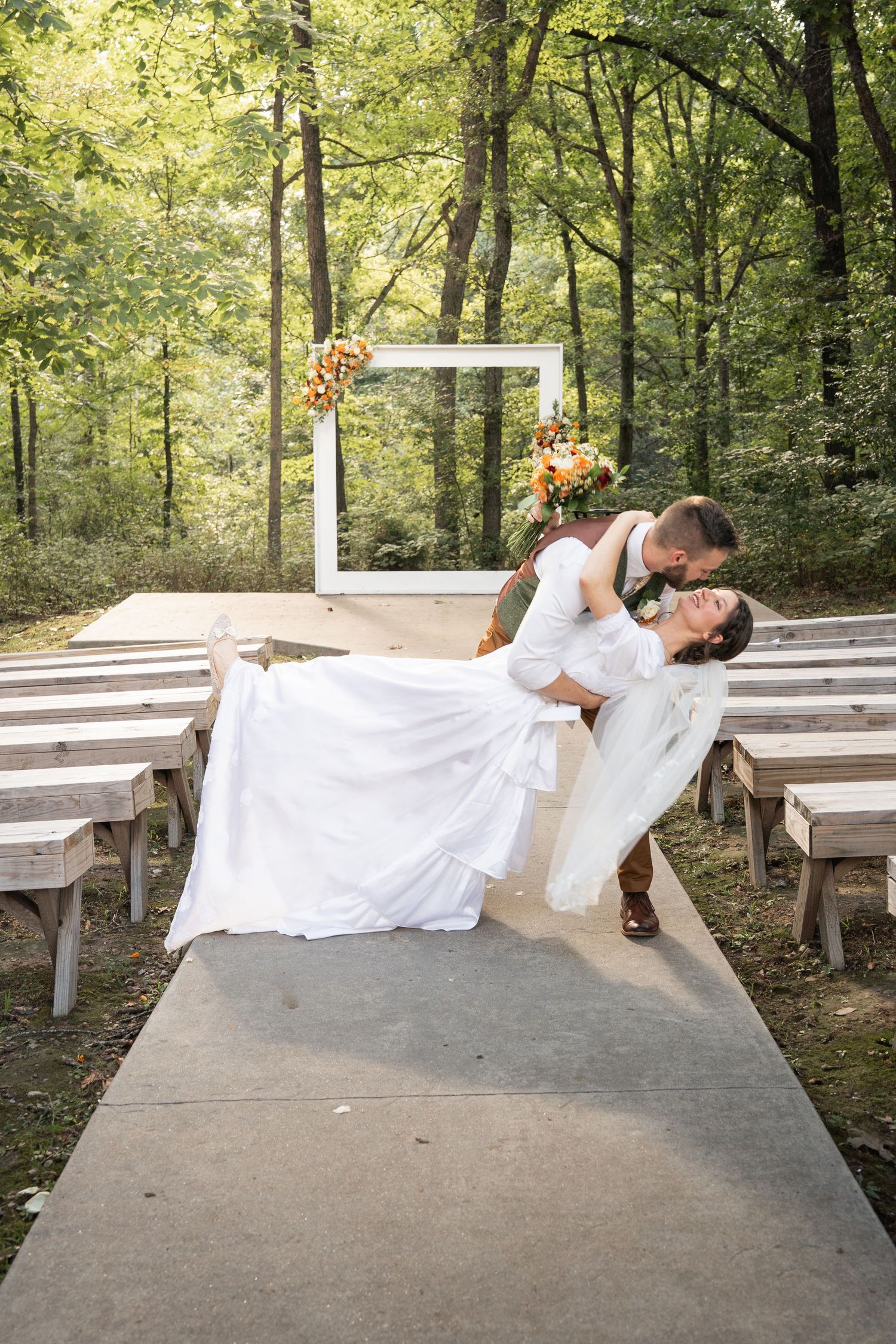 ©AnnaVonRiesenPhotography Wedding Photography | Color image of the groom dipping and kissing his bride in the aisle.