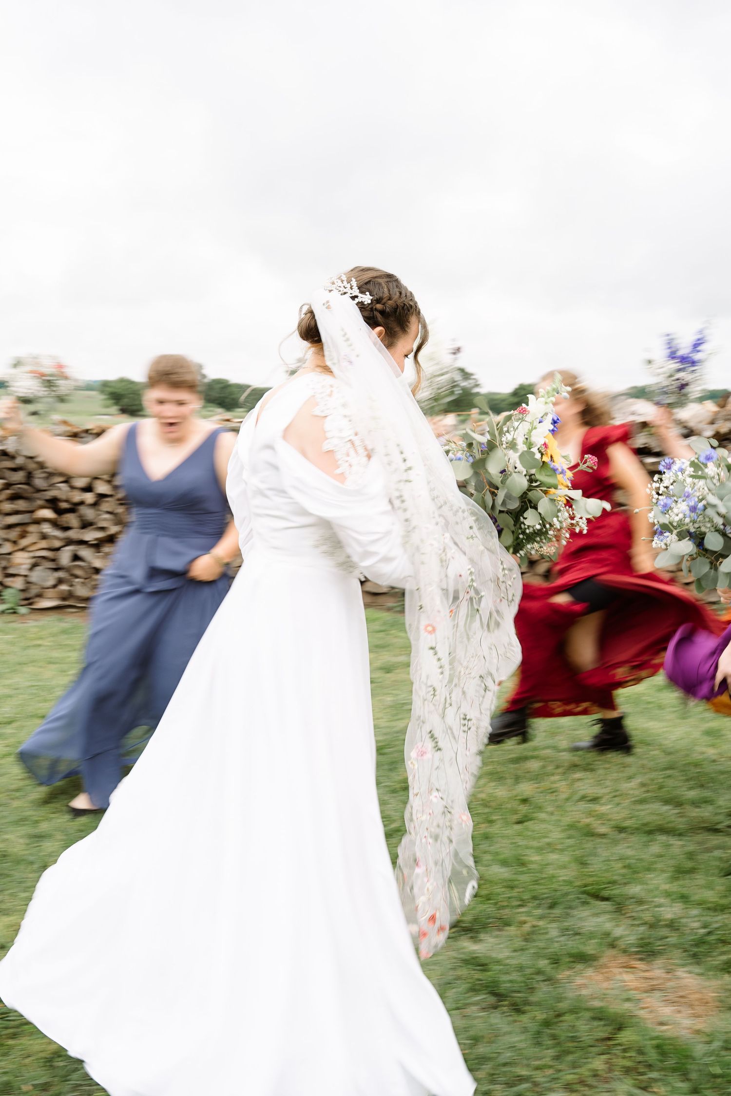 ©AnnaVonRiesenPhotography Wedding Photography | Color image of the bride & bridesmaids frollicking in a circle.