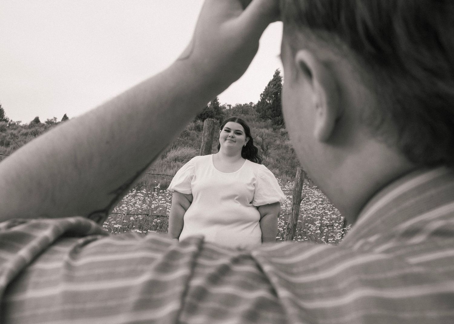Couple looking at each other in flower field engagement photos