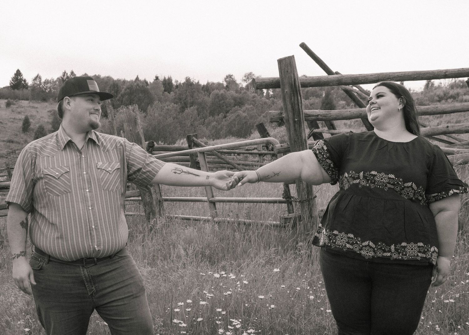 Couple holding hands in canyon flower field proposal