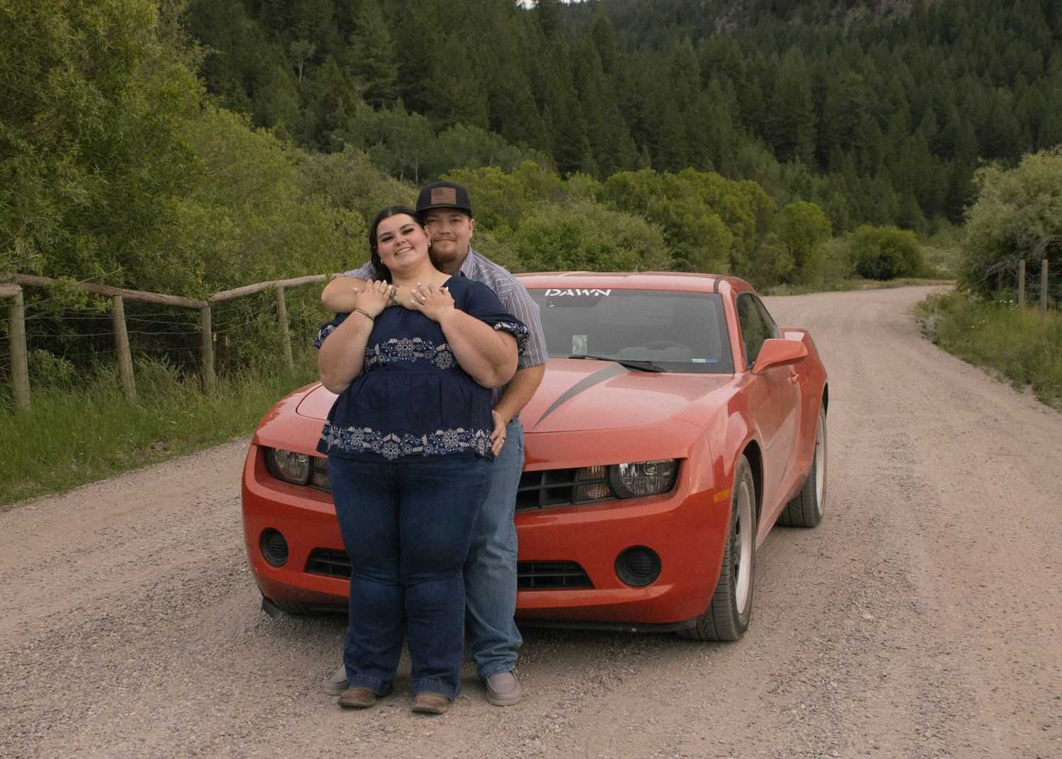 Engagement couple posing with car
