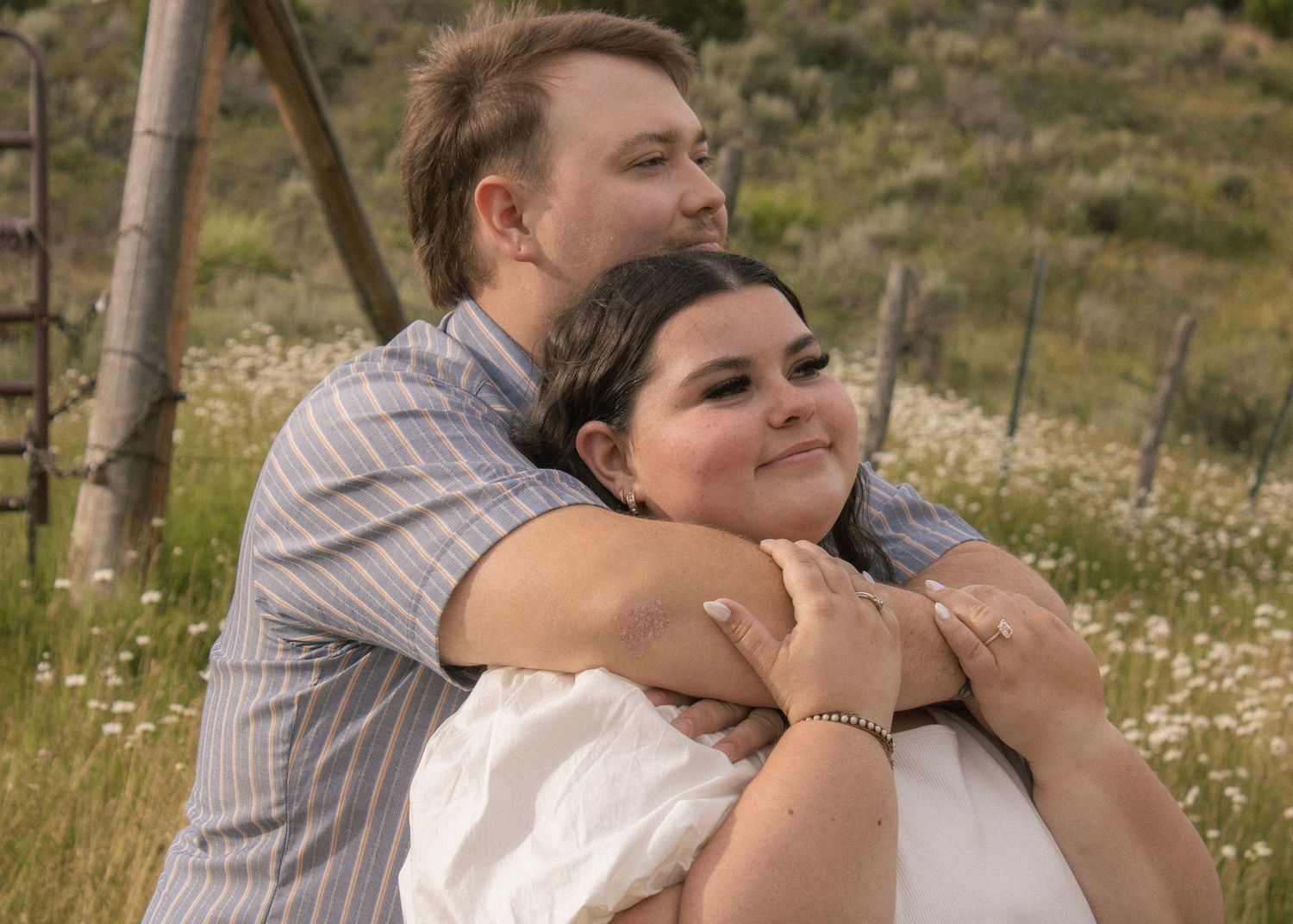 Couple hugging in flower field engagement photos