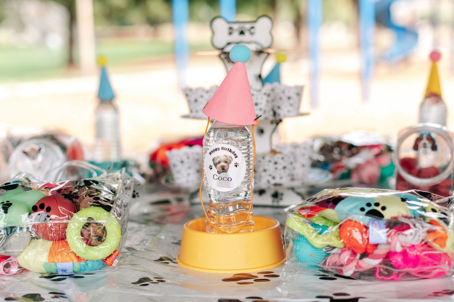 Dog-themed party table display with trophy centerpiece, colorful treats, and festive decorations.