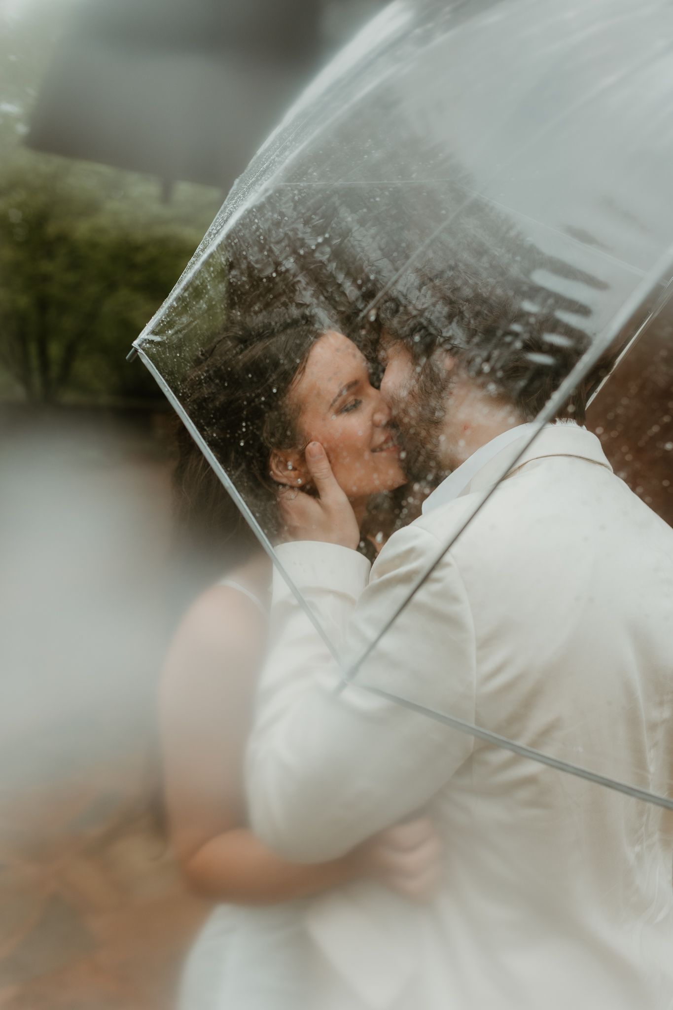 A romantic kiss through a rainy window creates a dreamy, artistic wedding photo effect Chattanooga Wedding Photographer