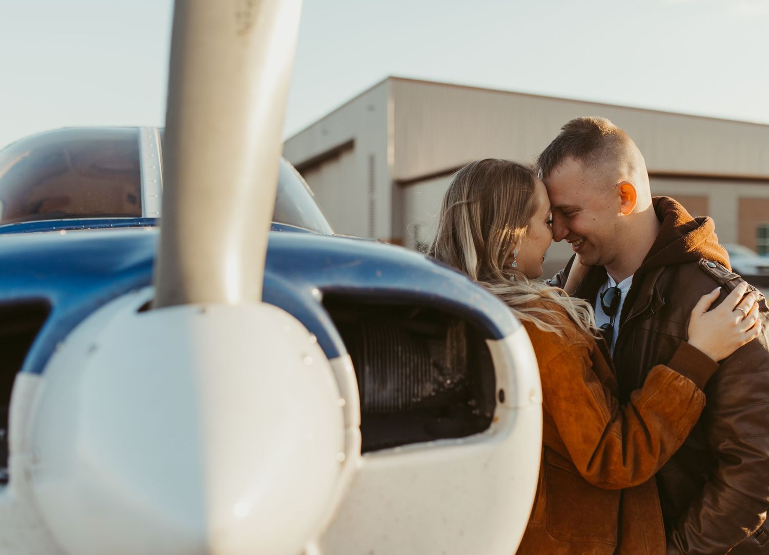 Romantic couple photoshoot by small aircraft at sunset.