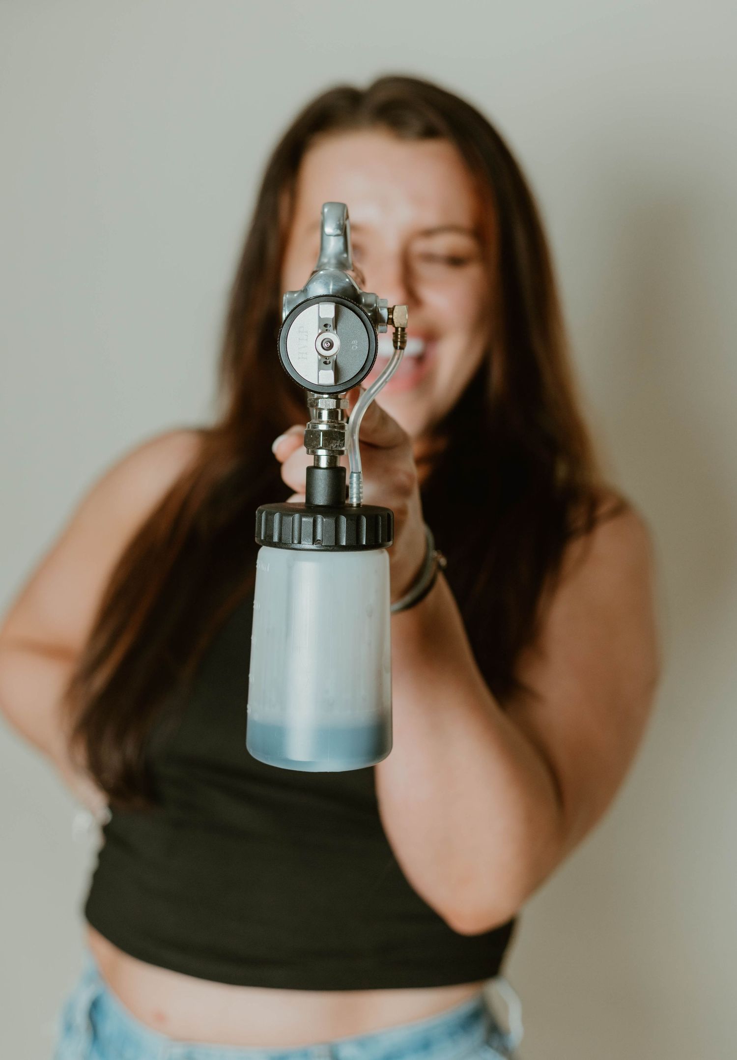 Creative portrait series with antique cameras and playful poses against neutral backdrop.