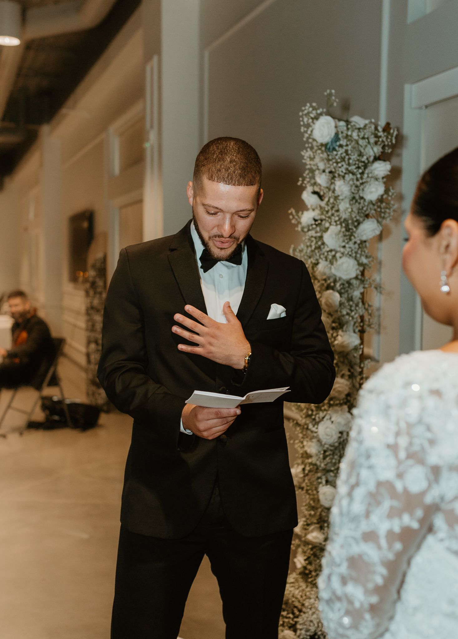 Emotional wedding ceremony moment captured in a modern white venue.