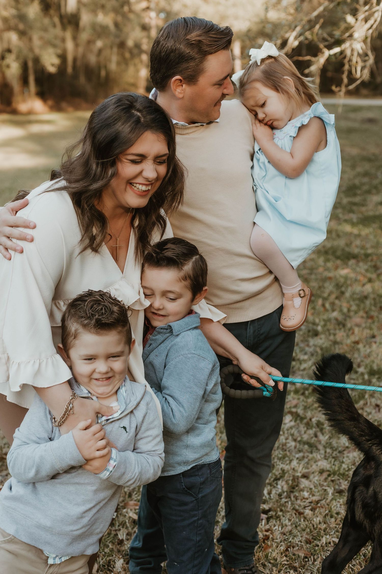 Family shares joyful candid moments together outdoors in warm sunlight.