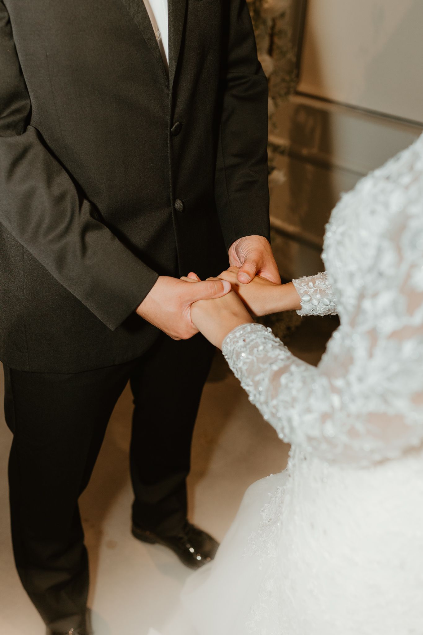 Close-up of hands holding during an intimate wedding ceremony moment.