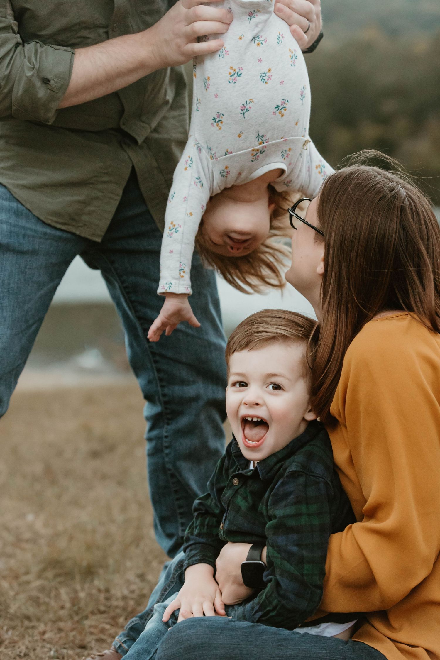 Candid family moments captured during a playful outdoor photo session.