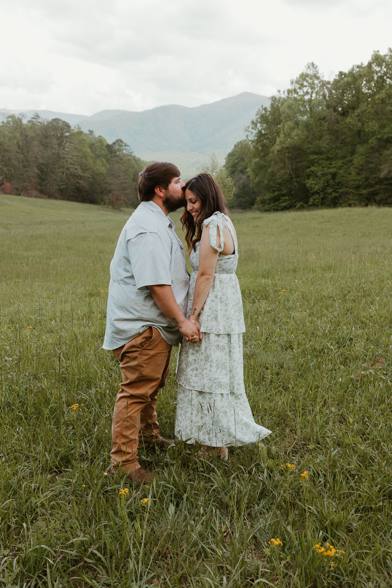 Sweet candid moments between a couple in a flowering mountain meadow.